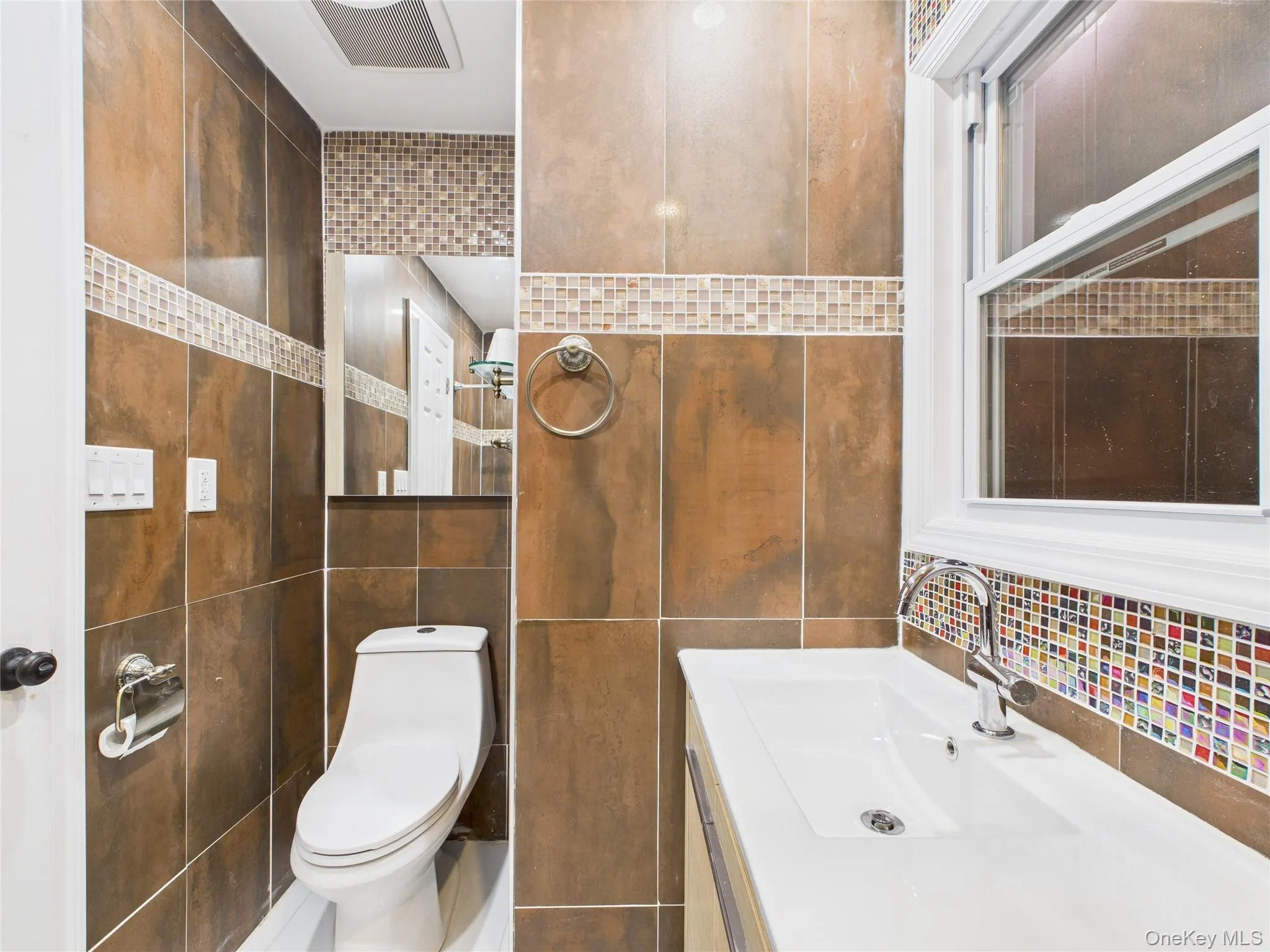 Half bath featuring vanity and tile walls Half bath featuring vanity and tile walls