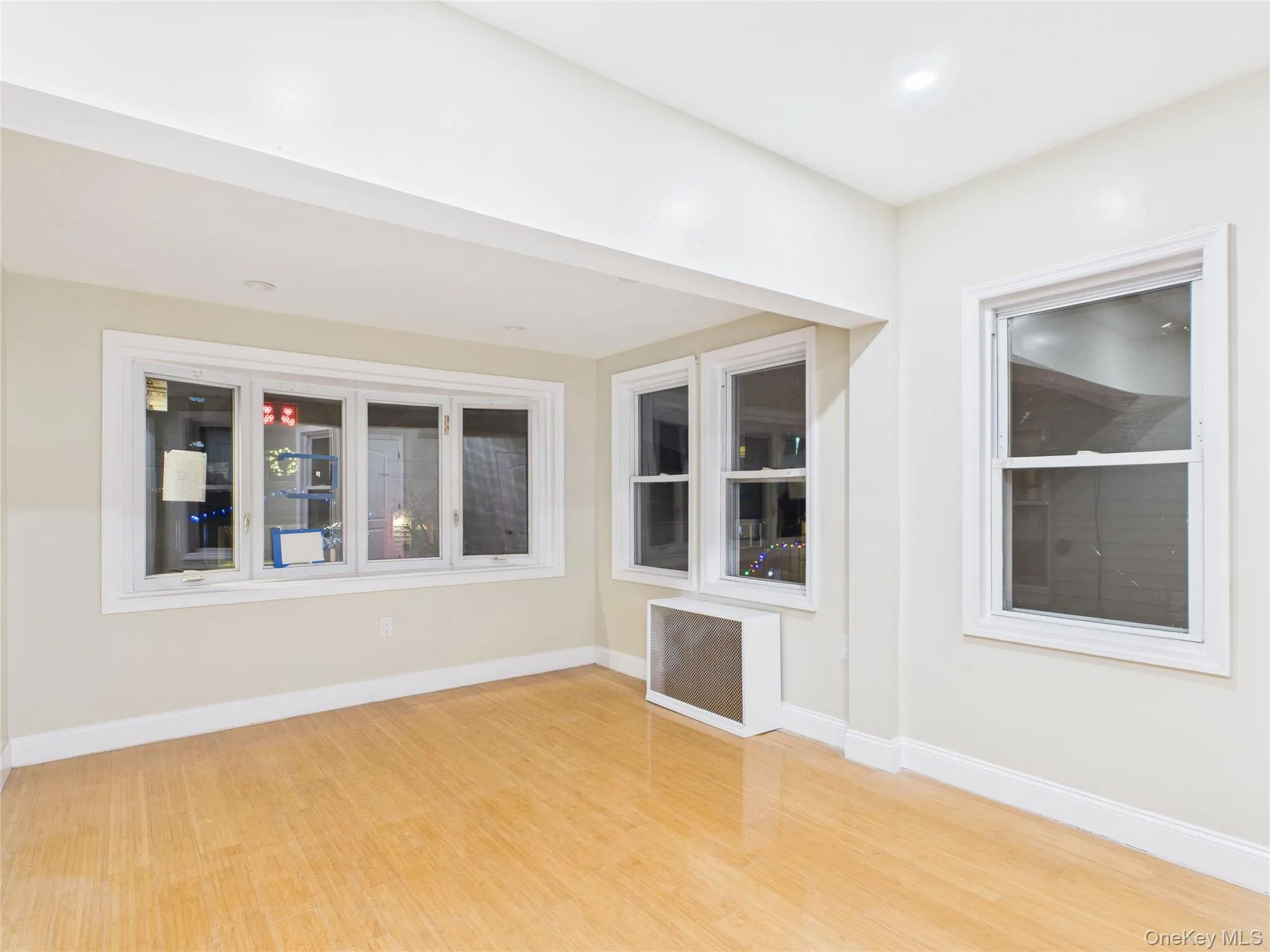 Empty room with radiator and light wood-style floors Empty room with radiator and light wood-style floors