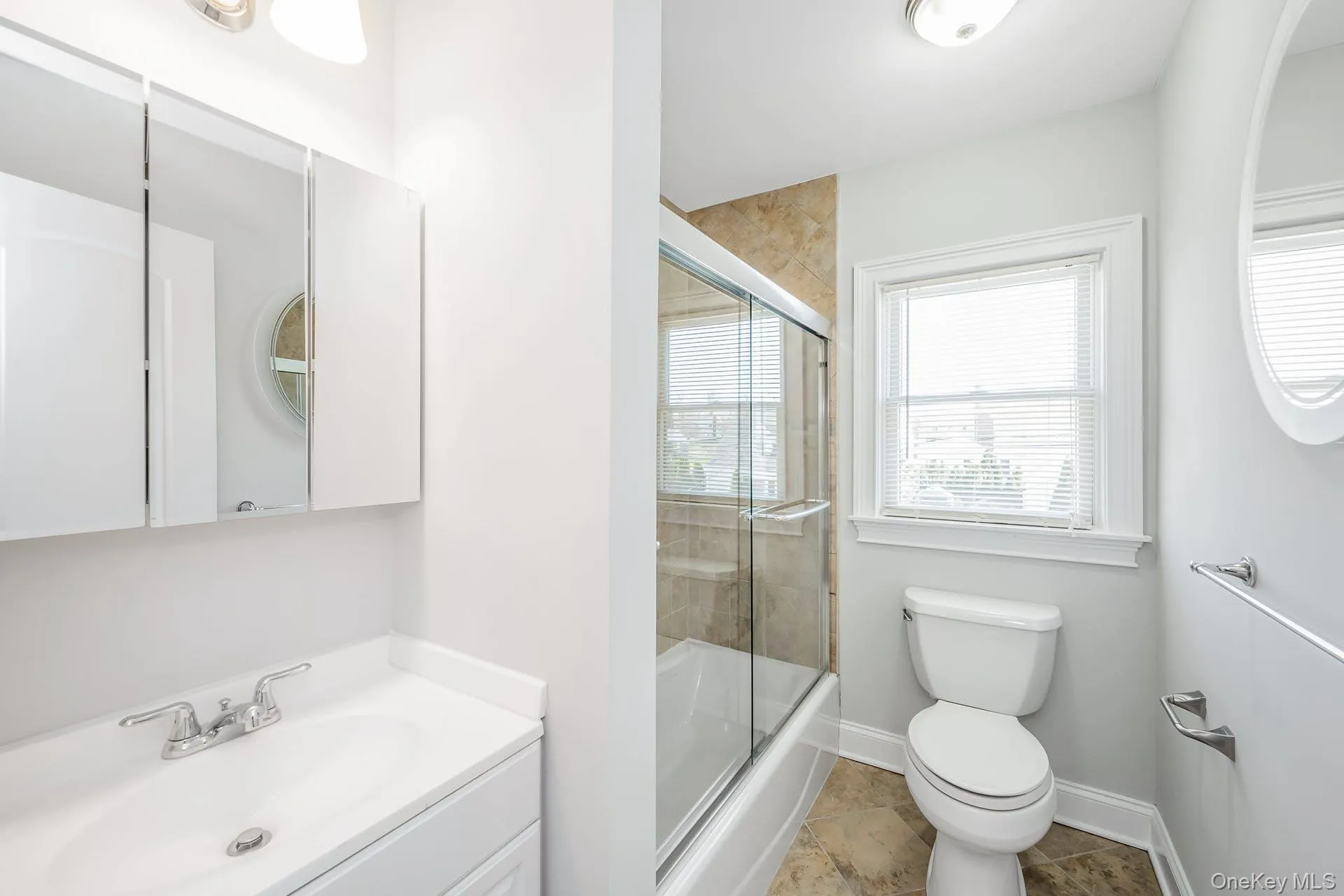 Bathroom with combined bath / shower with glass door and vanity Bathroom with combined bath / shower with glass door and vanity