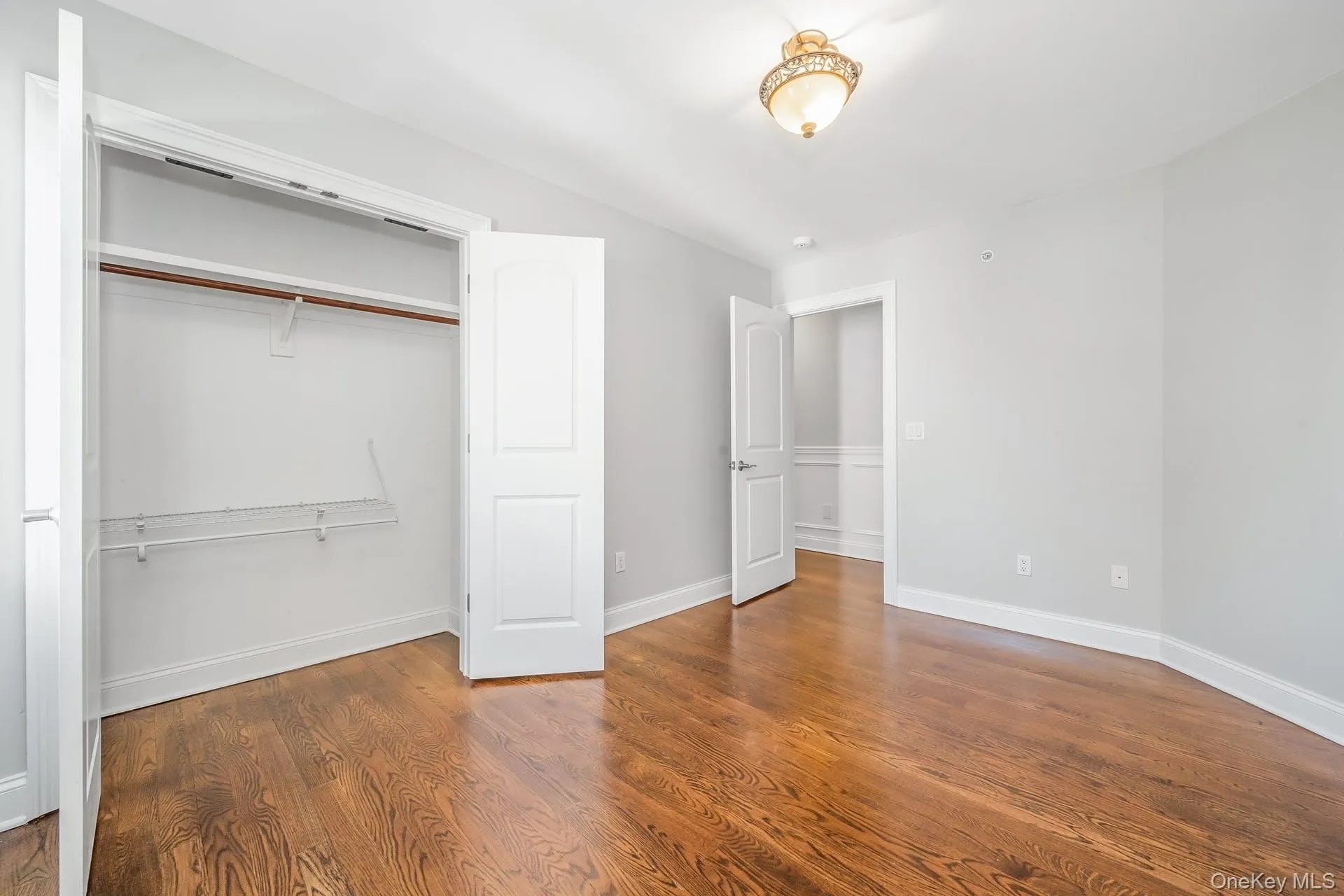 Unfurnished bedroom with wood finished floors and a closet Unfurnished bedroom with wood finished floors and a closet
