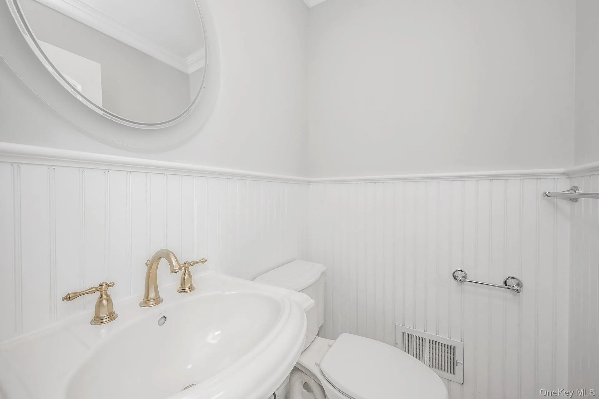 Half bathroom featuring wainscoting and ornamental molding Half bathroom featuring wainscoting and ornamental molding