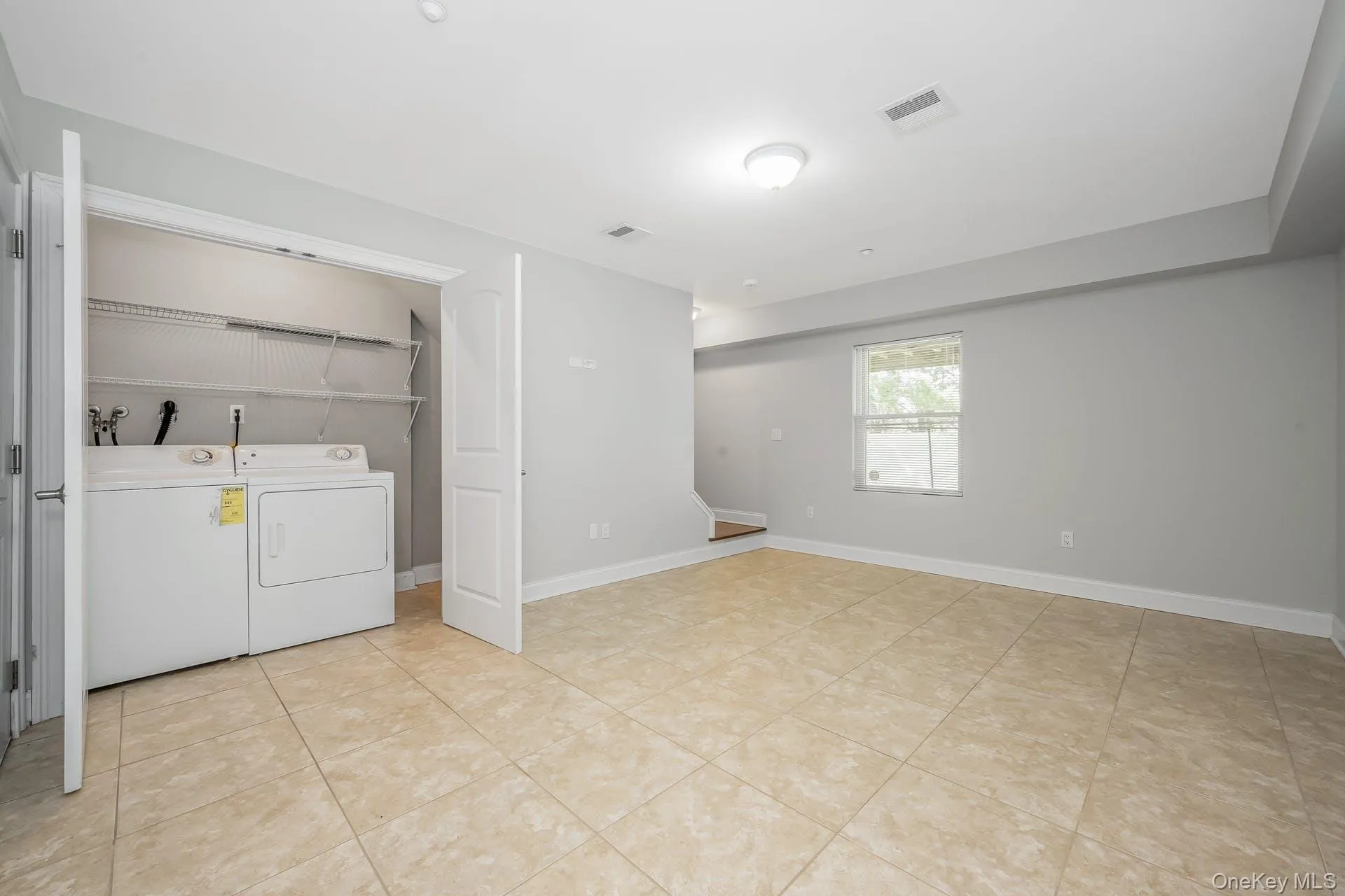 Laundry area with separate washer and dryer and light tile patterned flooring Laundry area with separate washer and dryer and light tile patterned flooring