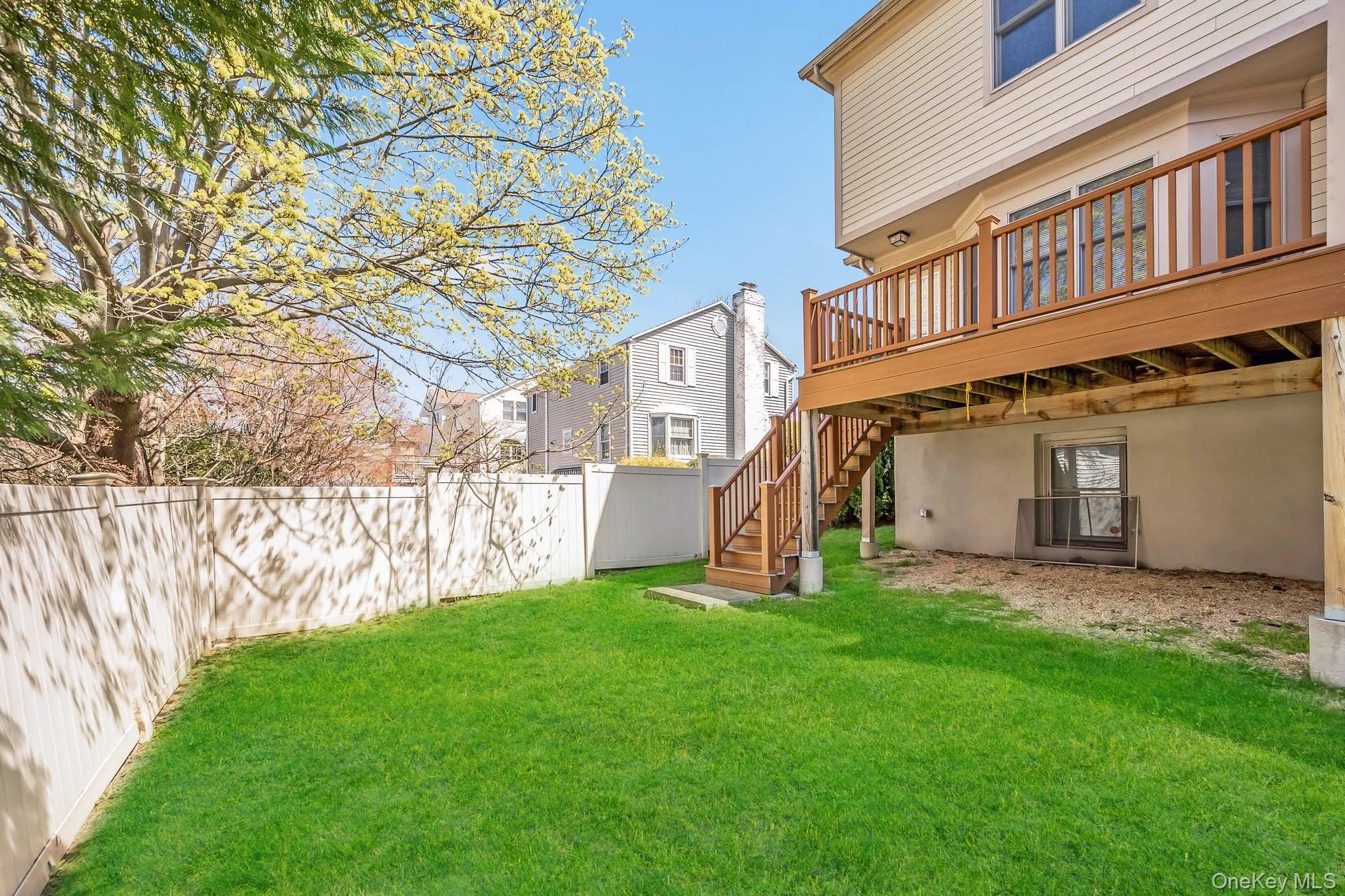 Fenced backyard featuring a deck and stairway Fenced backyard featuring a deck and stairway