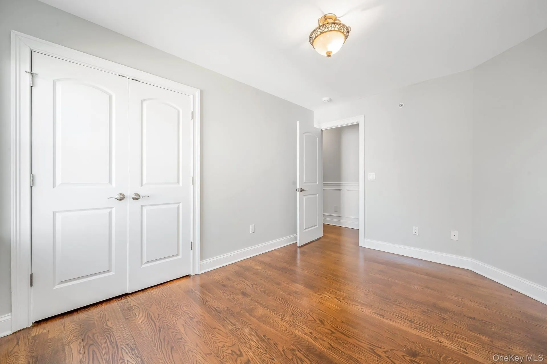 Unfurnished bedroom featuring wood finished floors and a closet Unfurnished bedroom featuring wood finished floors and a closet