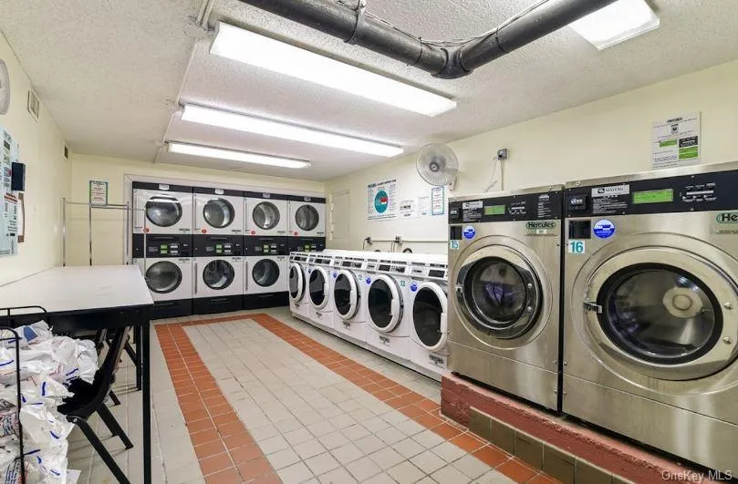 Washroom with a textured ceiling, stacked washer / drying machine, and washing machine and clothes dryer Washroom with a textured ceiling, stacked washer / drying machine, and washing machine and clothes dryer