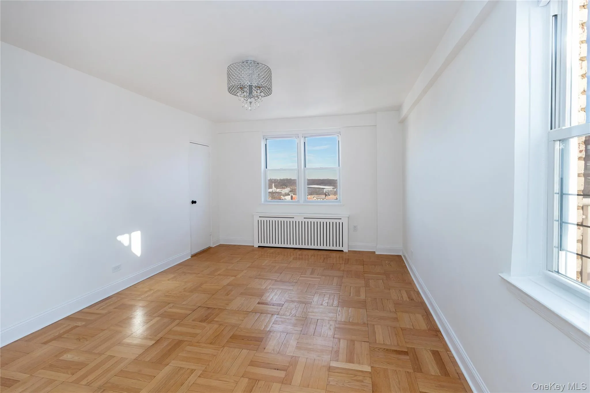 Empty room with radiator heating unit and a chandelier Empty room with radiator heating unit and a chandelier