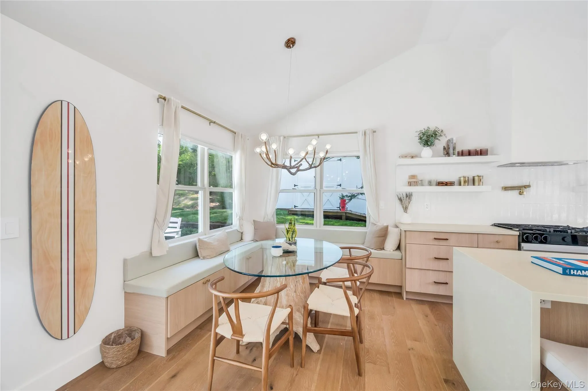 Dining room with breakfast area, light wood-type flooring, lofted ceiling, and a chandelier Dining room with breakfast area, light wood-type flooring, lofted ceiling, and a chandelier