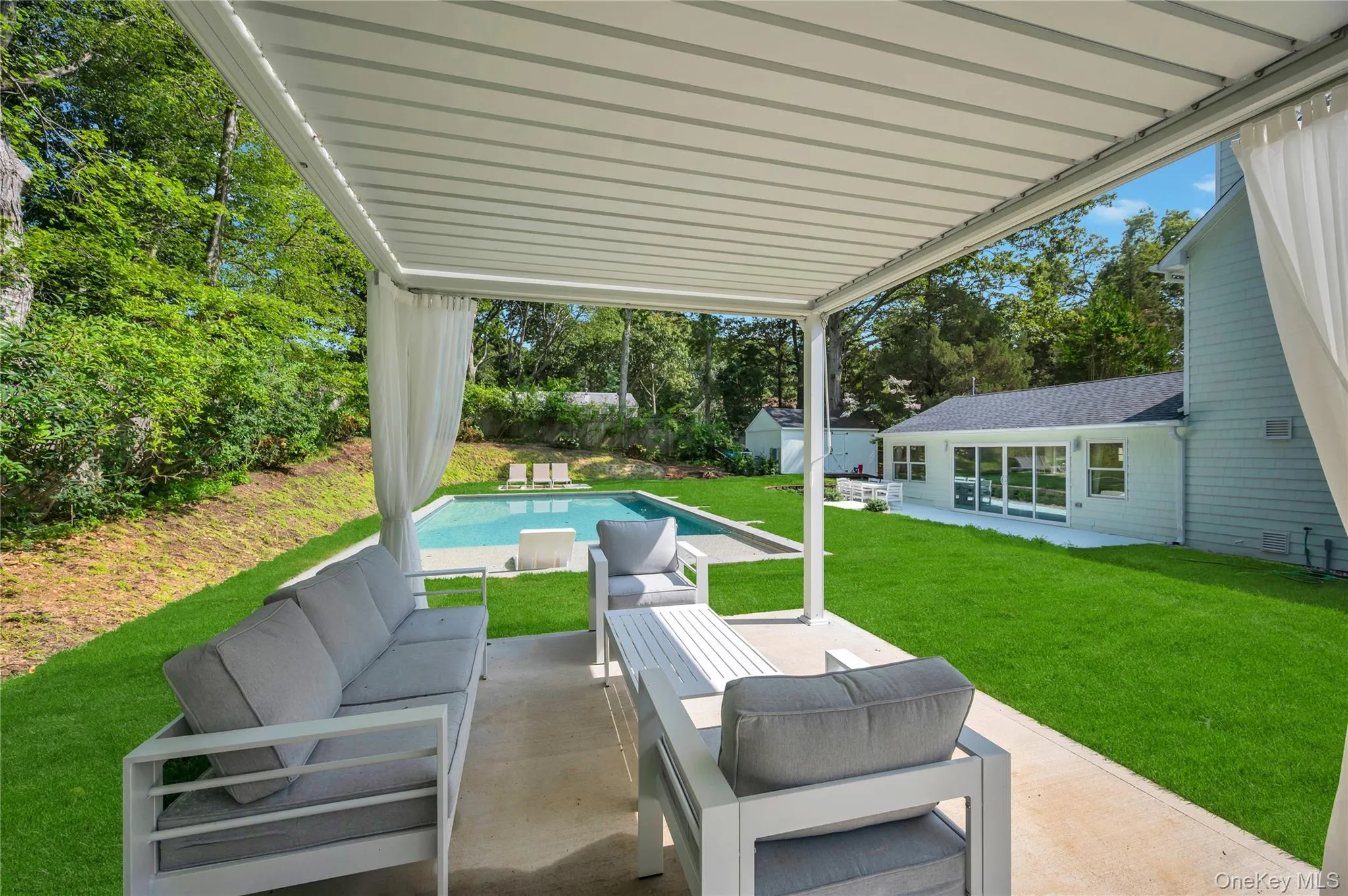 View of patio featuring outdoor lounge area and an outbuilding View of patio featuring outdoor lounge area and an outbuilding