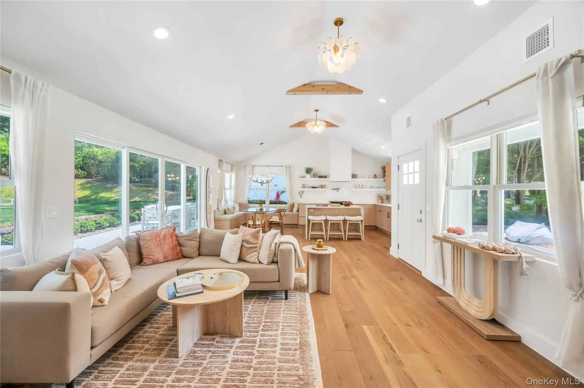 Living room featuring vaulted ceiling, a chandelier, light wood-type flooring, and recessed lighting Living room featuring vaulted ceiling, a chandelier, light wood-type flooring, and recessed lighting