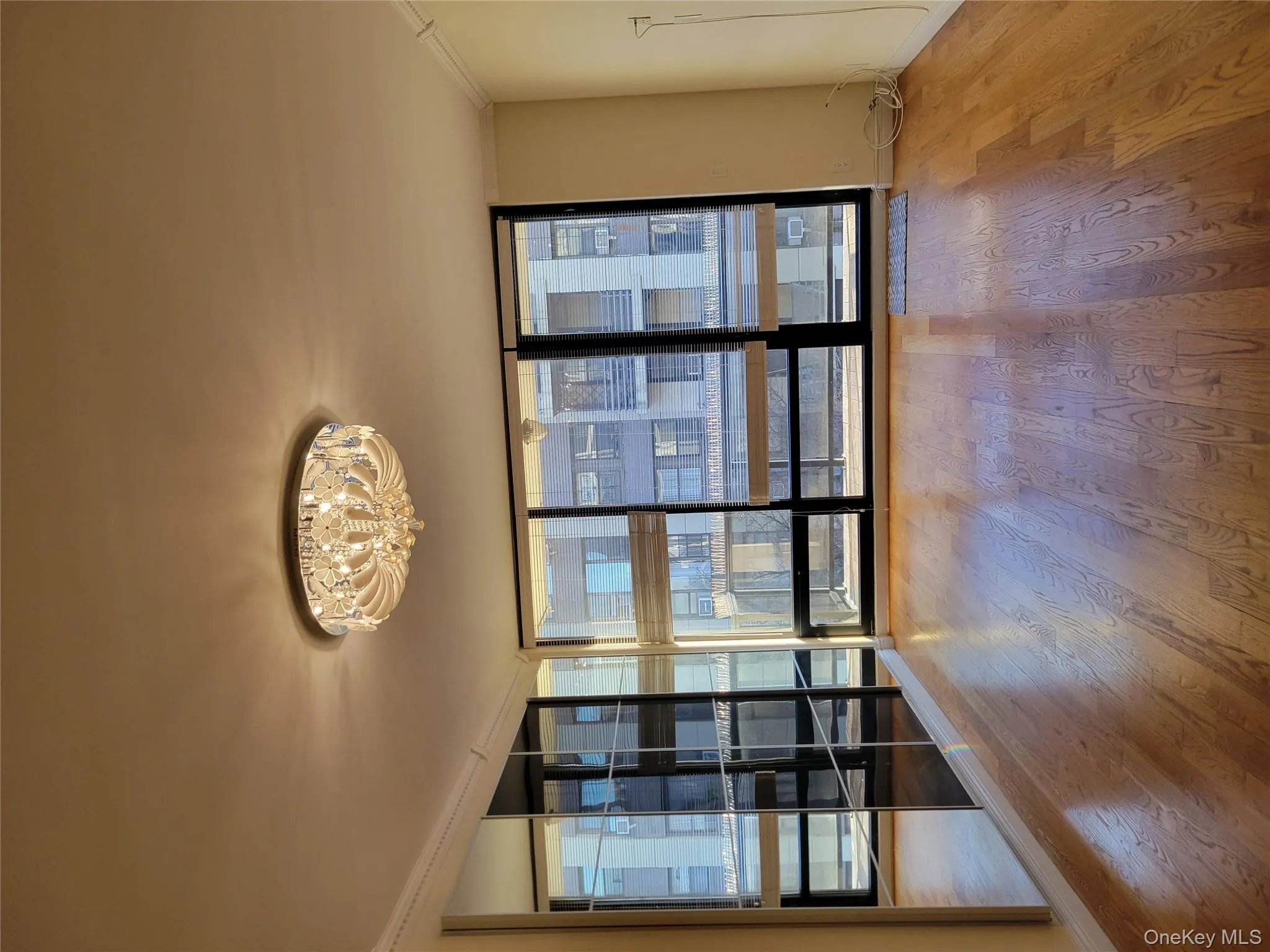 Spare room with floor to ceiling windows, crown molding, wood finished floors, and a chandelier Spare room with floor to ceiling windows, crown molding, wood finished floors, and a chandelier