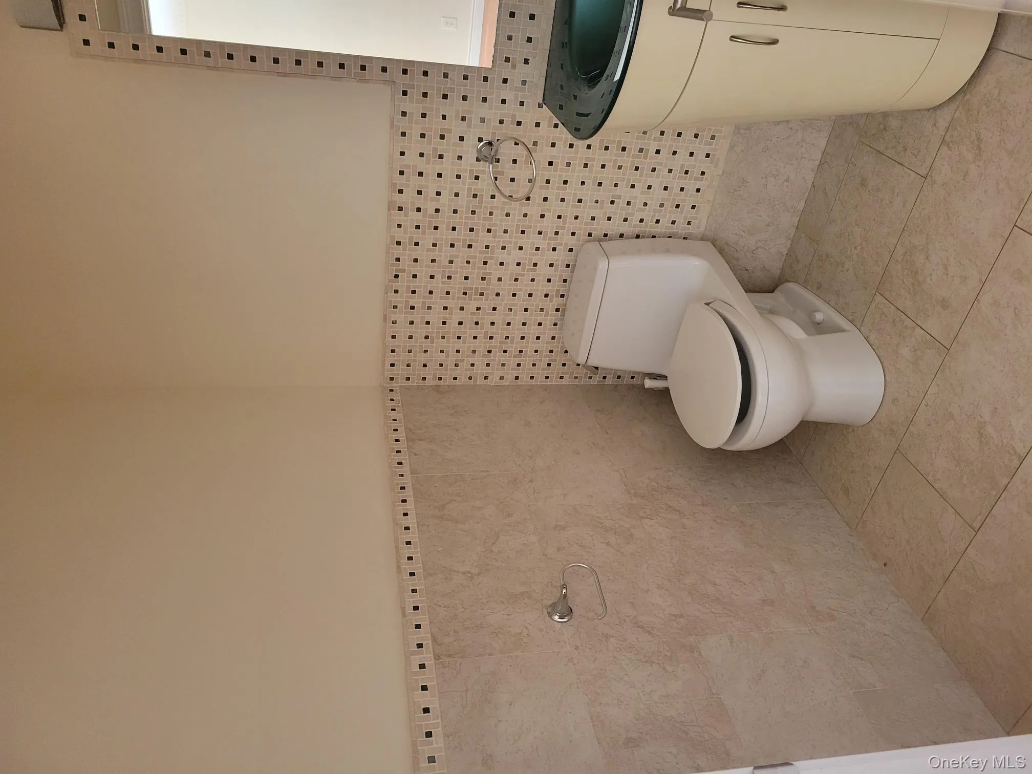 Half bathroom featuring vanity, wainscoting, light tile patterned floors, and tile walls Half bathroom featuring vanity, wainscoting, light tile patterned floors, and tile walls