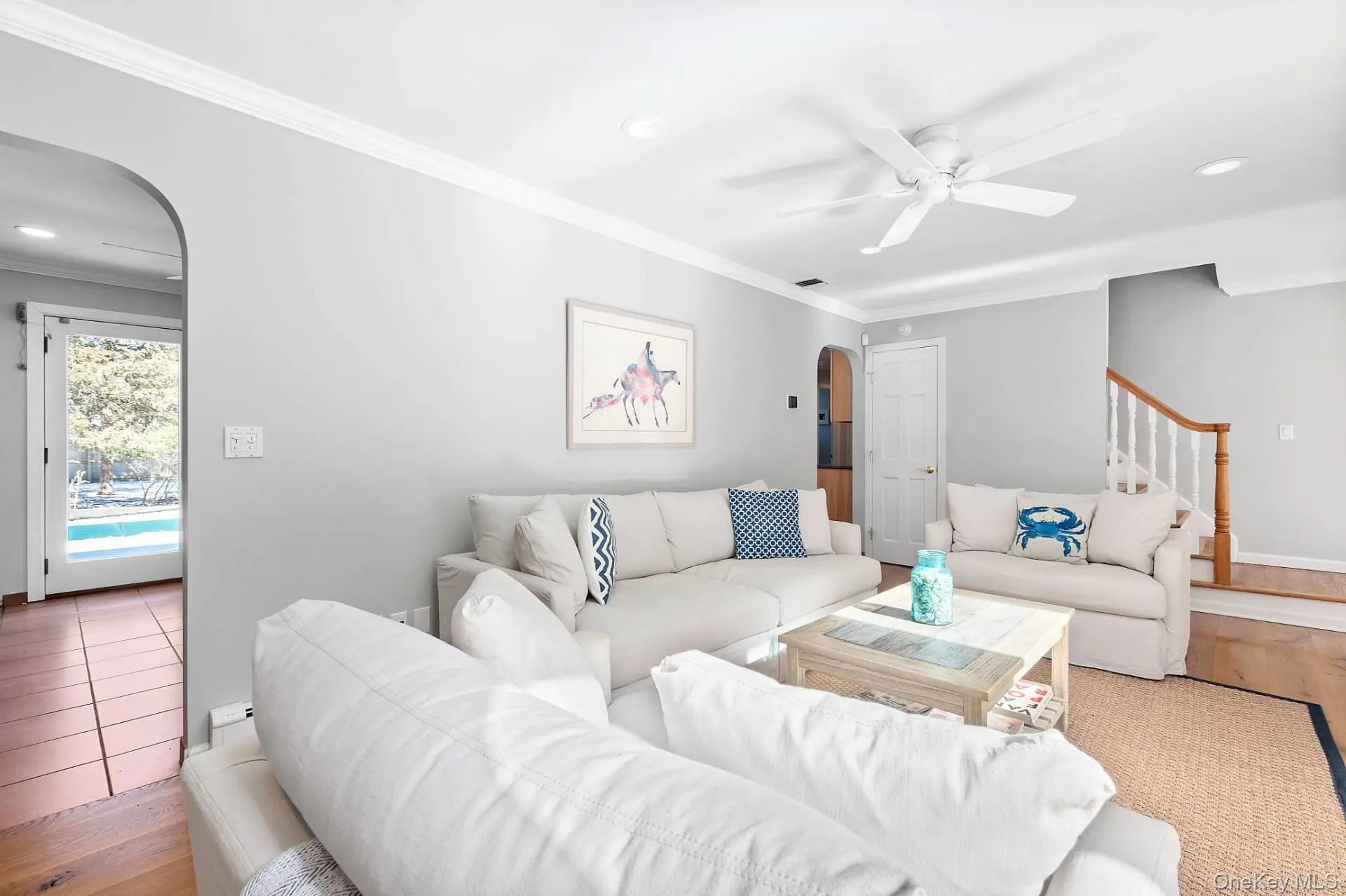 Living area featuring arched walkways, recessed lighting, wood finished floors, ornamental molding, and a ceiling fan Living area featuring arched walkways, recessed lighting, wood finished floors, ornamental molding, and a ceiling fan