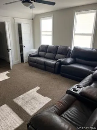 Living room featuring carpet flooring and ceiling fan Living room featuring carpet flooring and ceiling fan