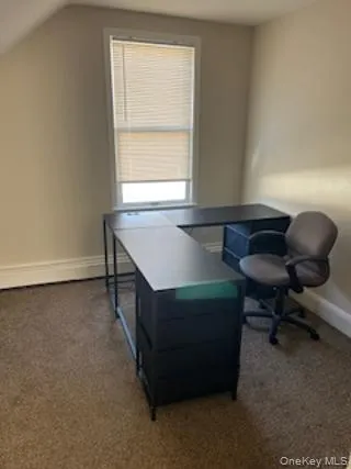 Home office featuring dark carpet and lofted ceiling Home office featuring dark carpet and lofted ceiling