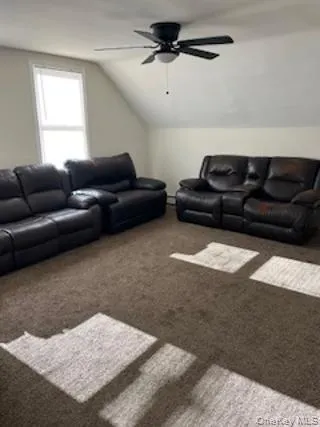 Living room featuring carpet flooring and lofted ceiling Living room featuring carpet flooring and lofted ceiling