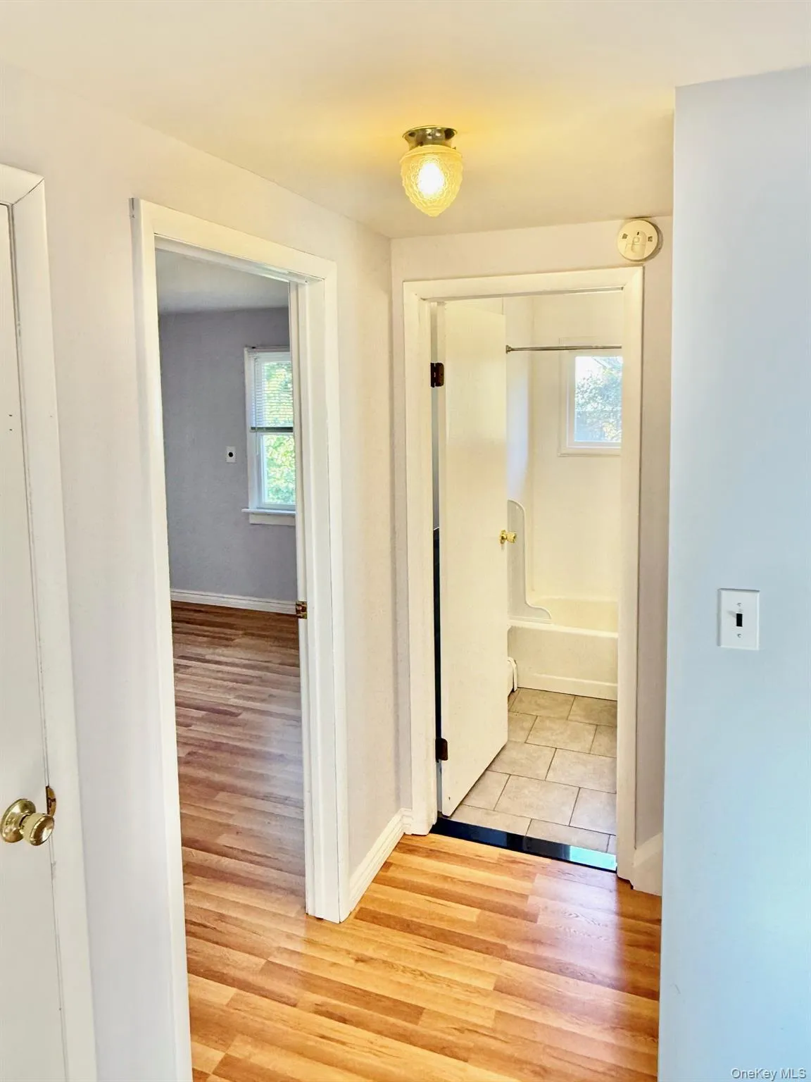 Hall featuring light wood-style flooring and baseboards Hall featuring light wood-style flooring and baseboards