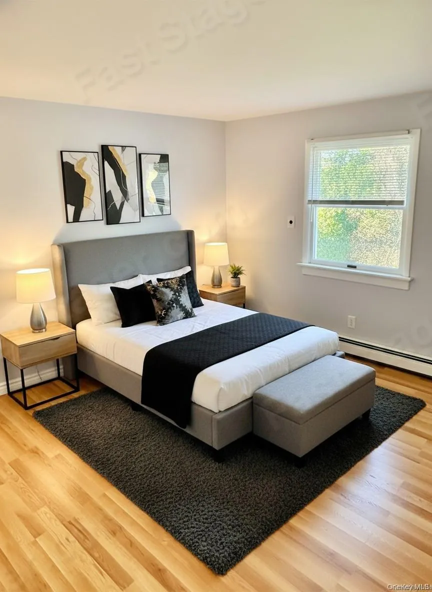 Bedroom featuring a baseboard heating unit and wood finished floors Bedroom featuring a baseboard heating unit and wood finished floors