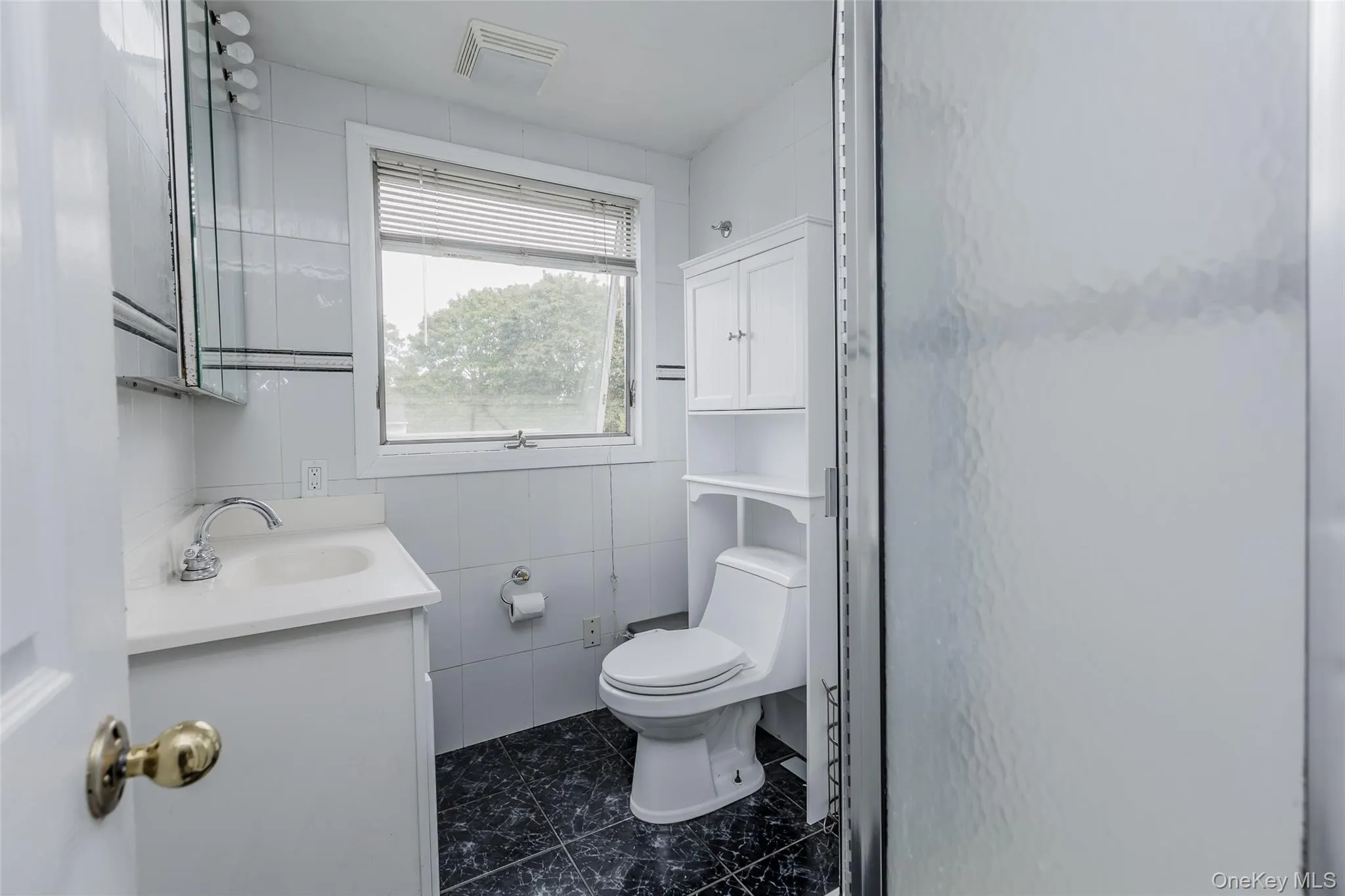 Bathroom featuring vanity, tile walls, and dark marble finish flooring Bathroom featuring vanity, tile walls, and dark marble finish flooring