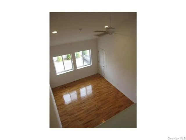 The spacious living room has a vaulted ceiling, gleaming oak wood floors, a ceiling light fan, recessed lighting, and a door to a bonus storage closet. The spacious living room has a vaulted ceiling, gleaming oak wood floors, a ceiling light fan, recessed lighting, and a door to a bonus storage closet.