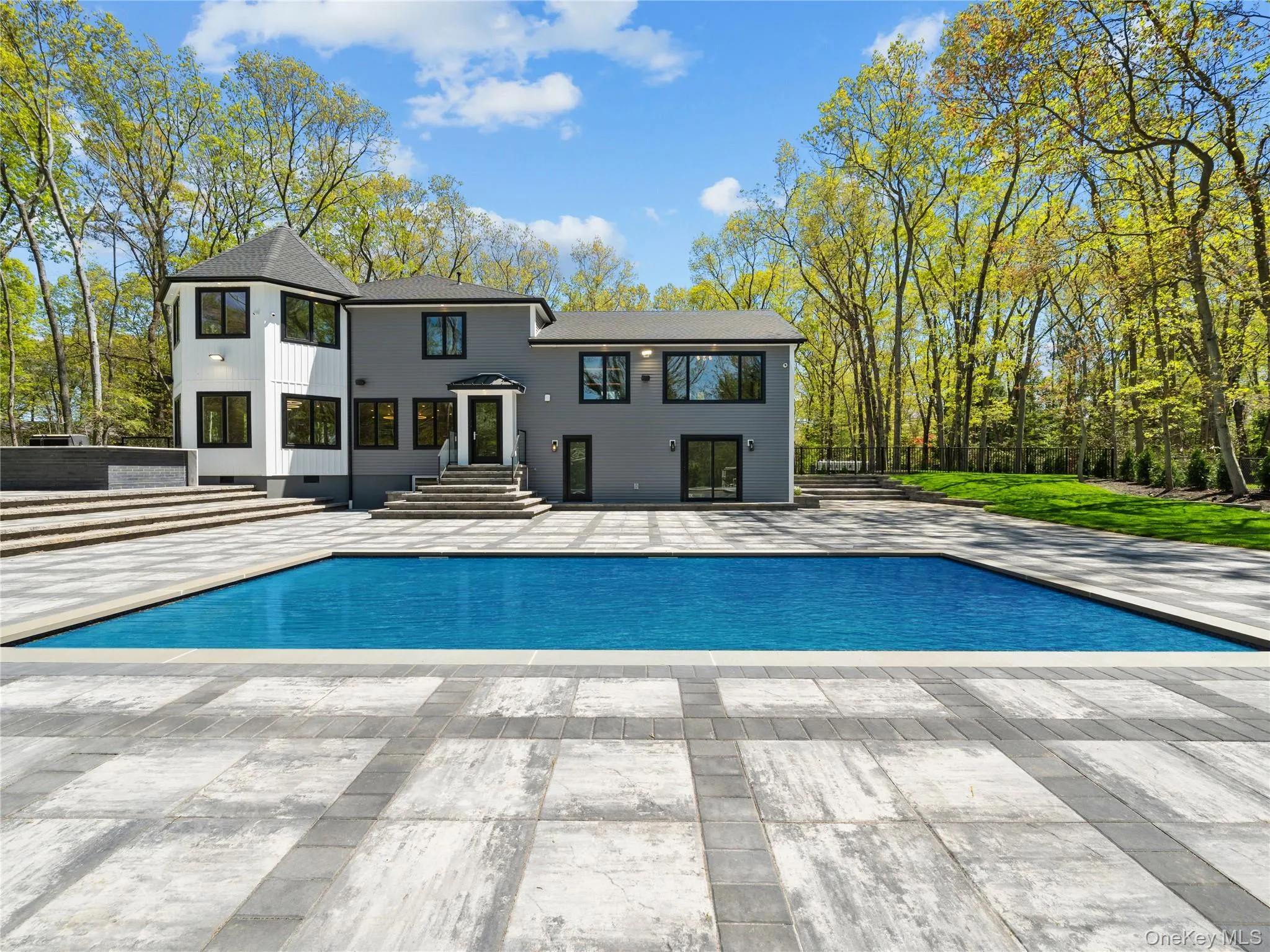 Rear view of house with an outdoor pool, a patio, and a shingled roof Rear view of house with an outdoor pool, a patio, and a shingled roof