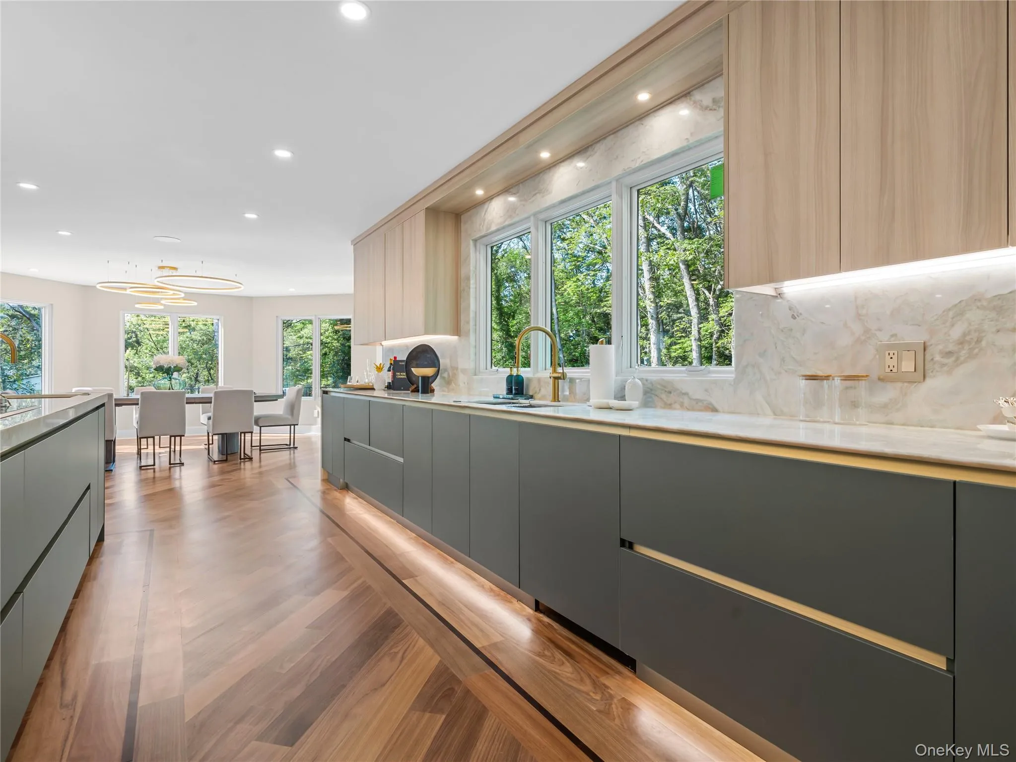 Kitchen with modern cabinets, healthy amount of natural light, light wood-type flooring, backsplash, and recessed lighting Kitchen with modern cabinets, healthy amount of natural light, light wood-type flooring, backsplash, and recessed lighting