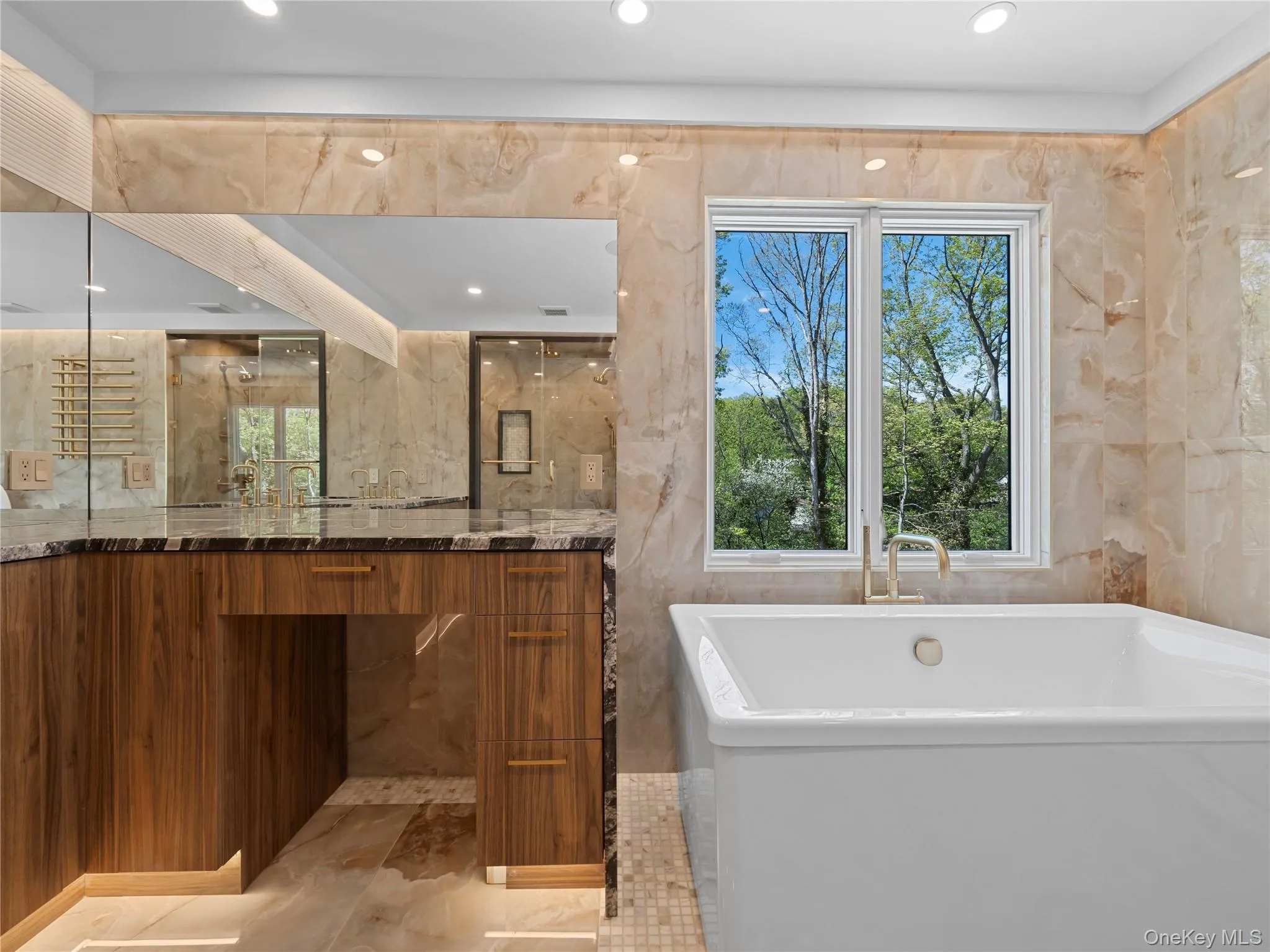 Full bathroom featuring vanity, a soaking tub, recessed lighting, and tile walls Full bathroom featuring vanity, a soaking tub, recessed lighting, and tile walls