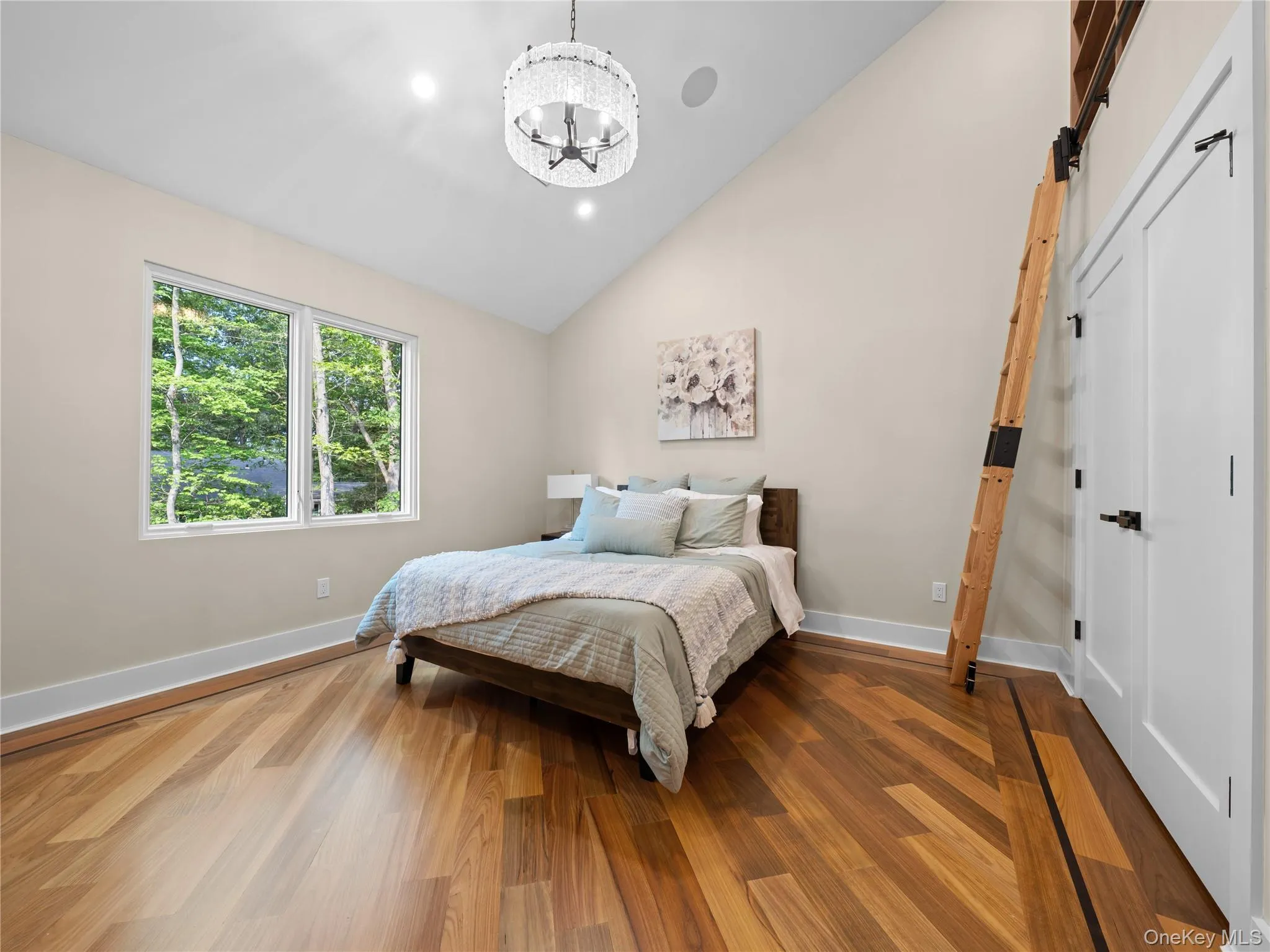 Bedroom with wood finished floors, recessed lighting, a chandelier, and high vaulted ceiling Bedroom with wood finished floors, recessed lighting, a chandelier, and high vaulted ceiling