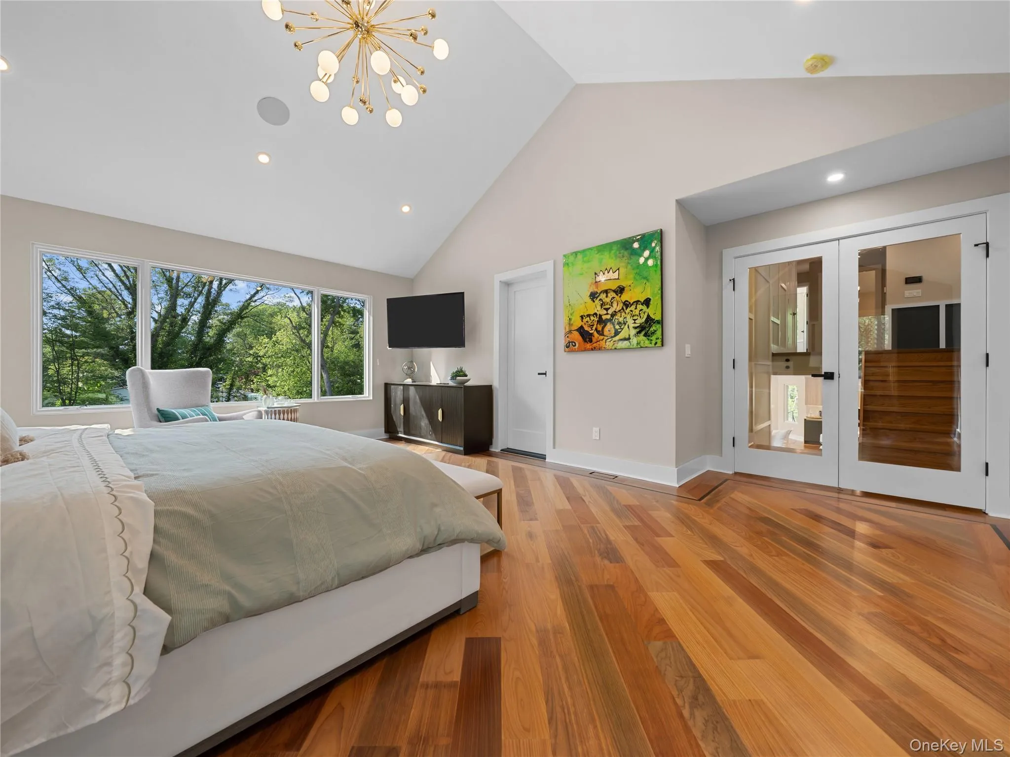 Bedroom featuring french doors, light wood finished floors, a chandelier, recessed lighting, and high vaulted ceiling Bedroom featuring french doors, light wood finished floors, a chandelier, recessed lighting, and high vaulted ceiling