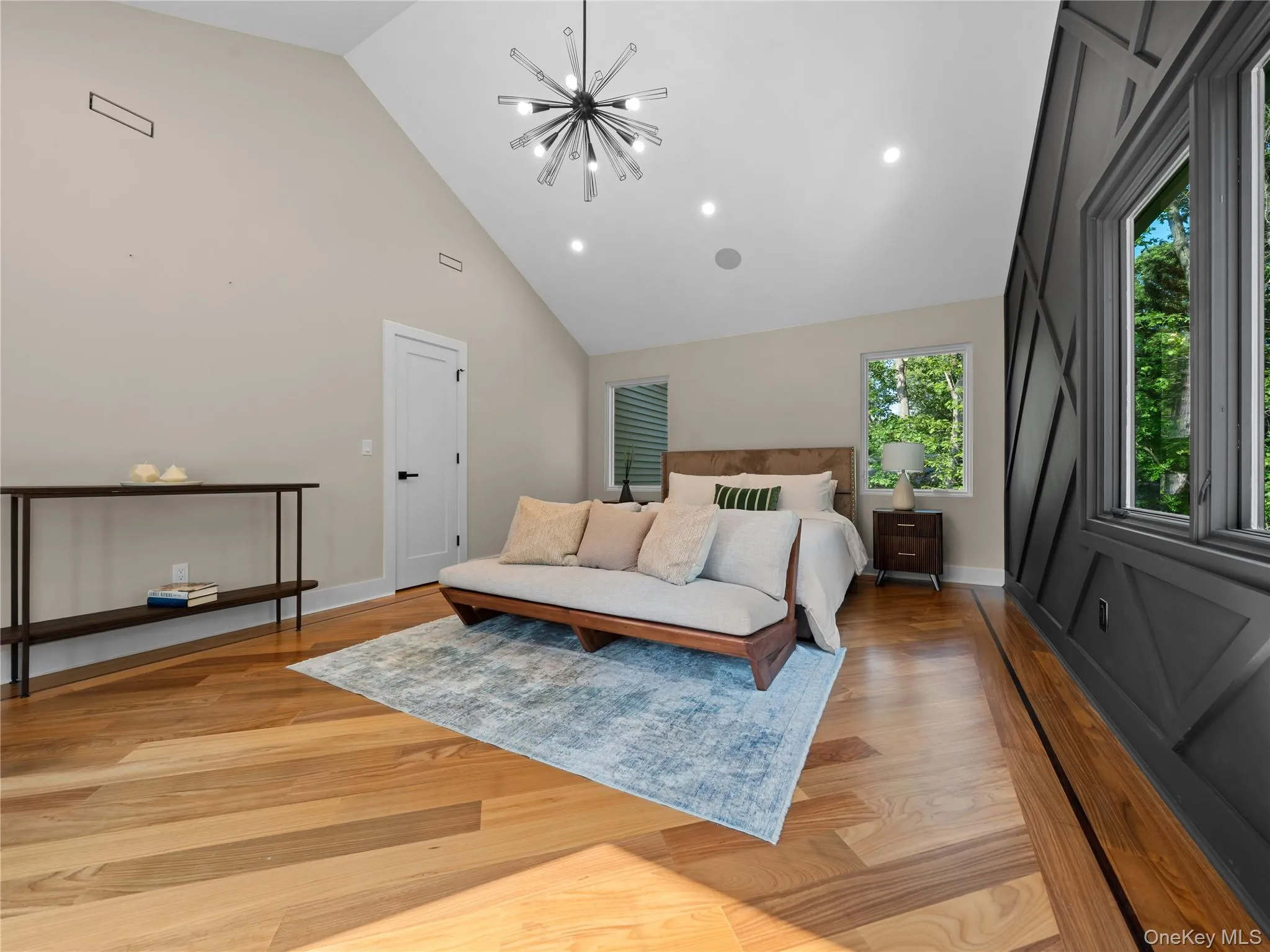 Bedroom with light wood-style flooring, a chandelier, high vaulted ceiling, and recessed lighting Bedroom with light wood-style flooring, a chandelier, high vaulted ceiling, and recessed lighting