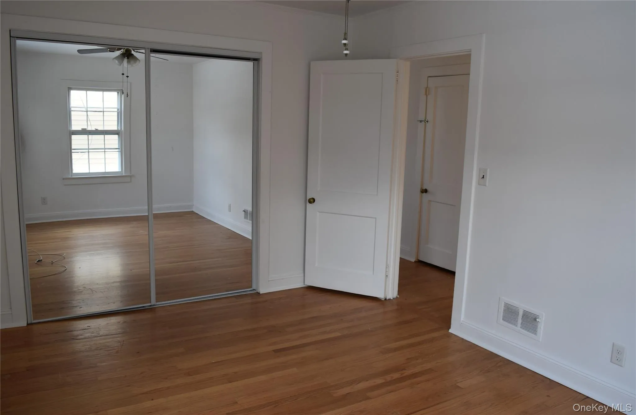 Unfurnished bedroom featuring wood finished floors, a closet, and a ceiling fan Unfurnished bedroom featuring wood finished floors, a closet, and a ceiling fan