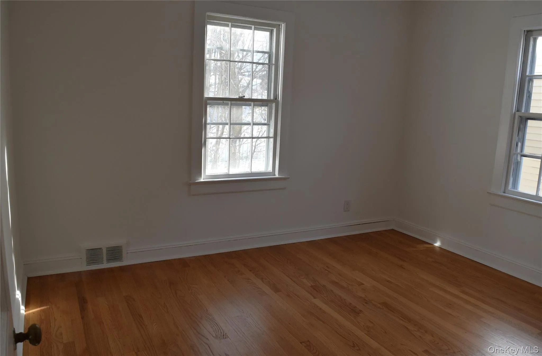 Unfurnished room with light wood-type flooring and baseboards Unfurnished room with light wood-type flooring and baseboards