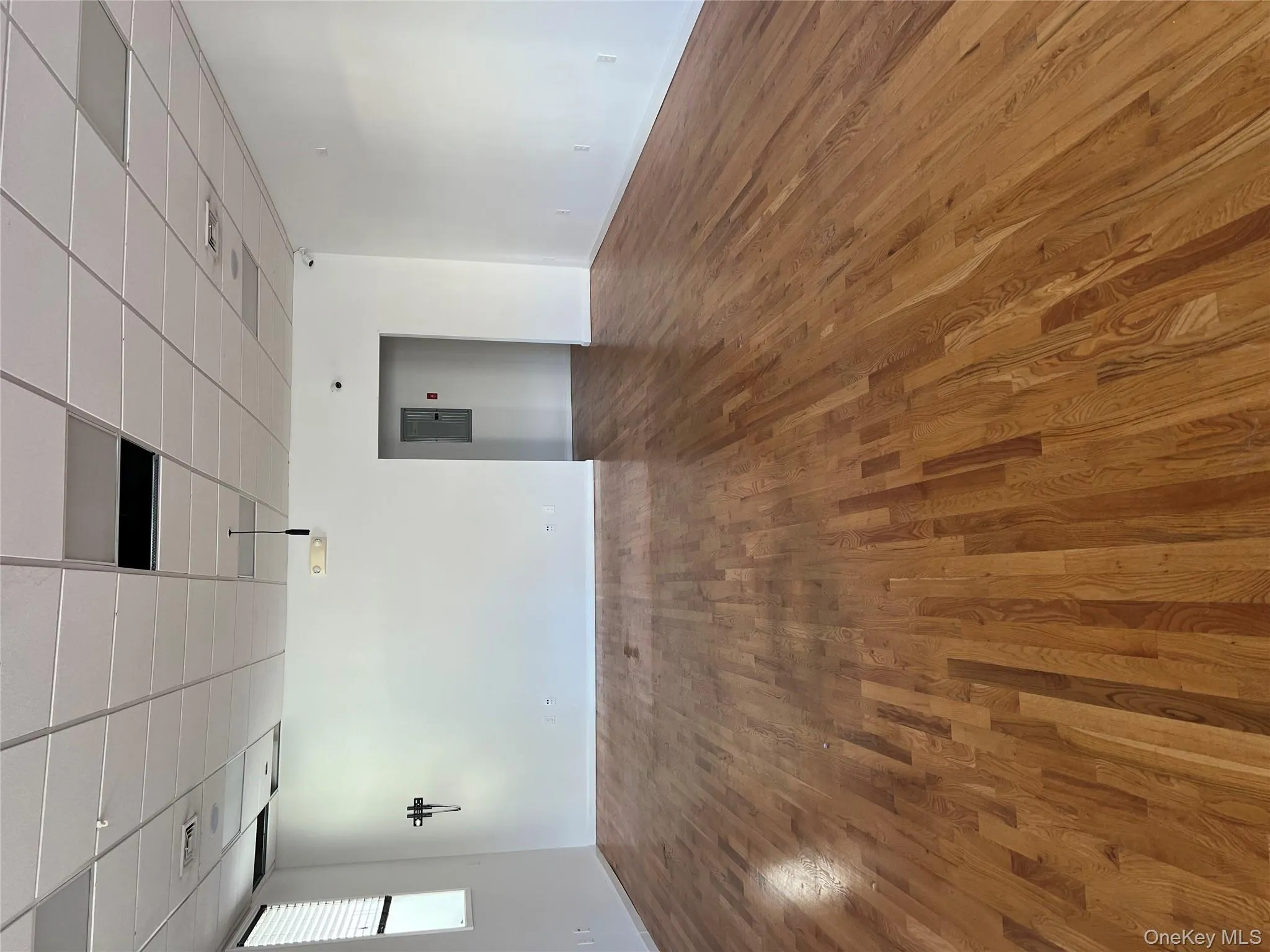 Empty room featuring a paneled ceiling, dark wood finished floors, and electric panel Empty room featuring a paneled ceiling, dark wood finished floors, and electric panel