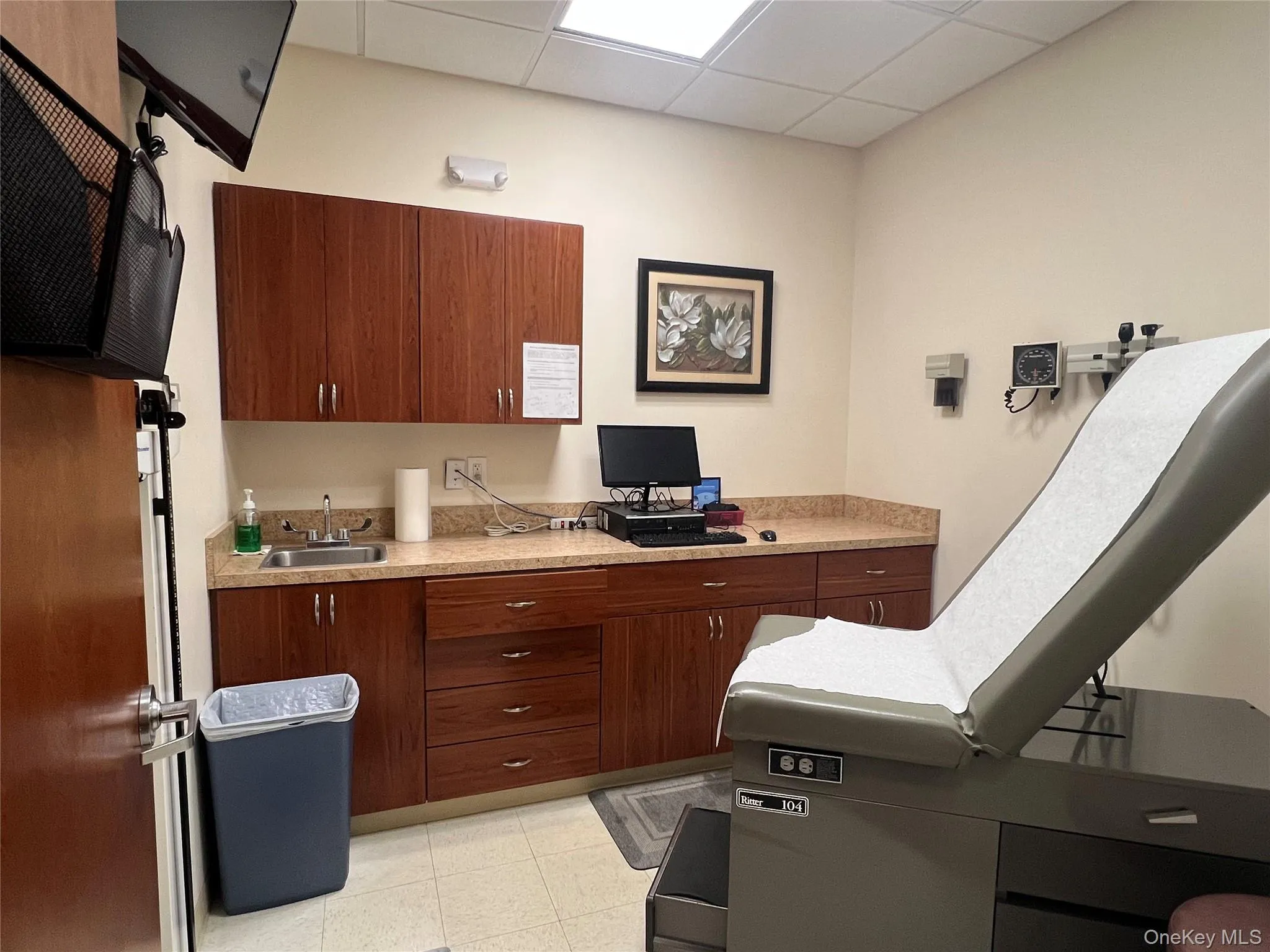 Kitchen featuring light countertops, a drop ceiling, brown cabinets, and an office area Kitchen featuring light countertops, a drop ceiling, brown cabinets, and an office area