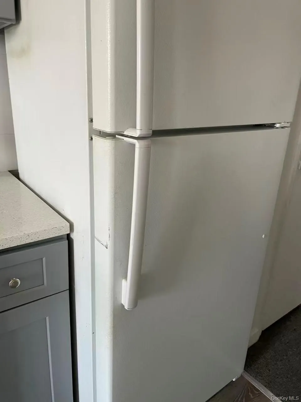 Kitchen view of gray cabinetry and freestanding refrigerator Kitchen view of gray cabinetry and freestanding refrigerator