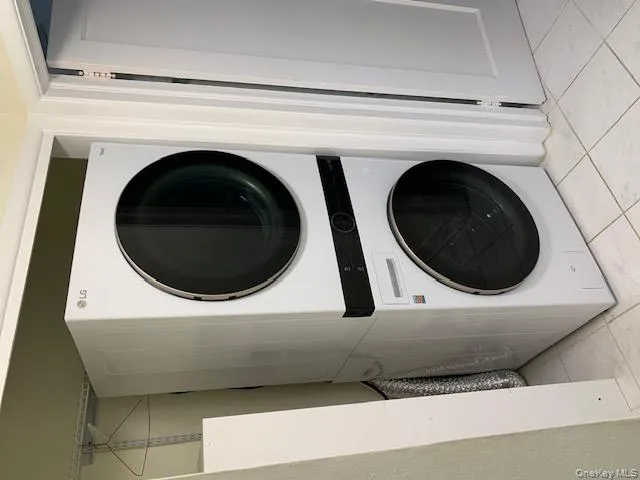 Washroom featuring stacked washer / drying machine Washroom featuring stacked washer / drying machine