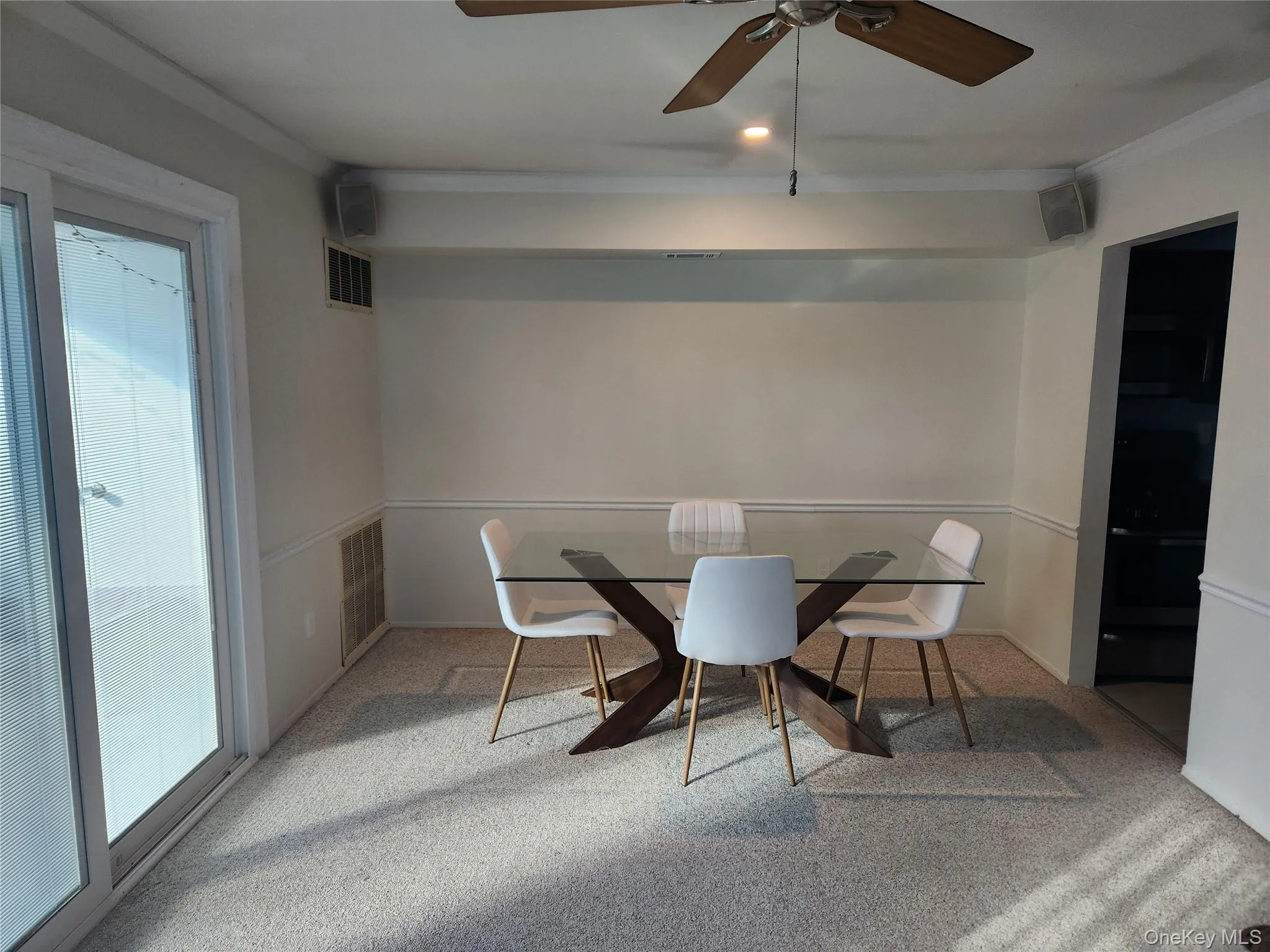 Carpeted dining space with crown molding and a ceiling fan Carpeted dining space with crown molding and a ceiling fan