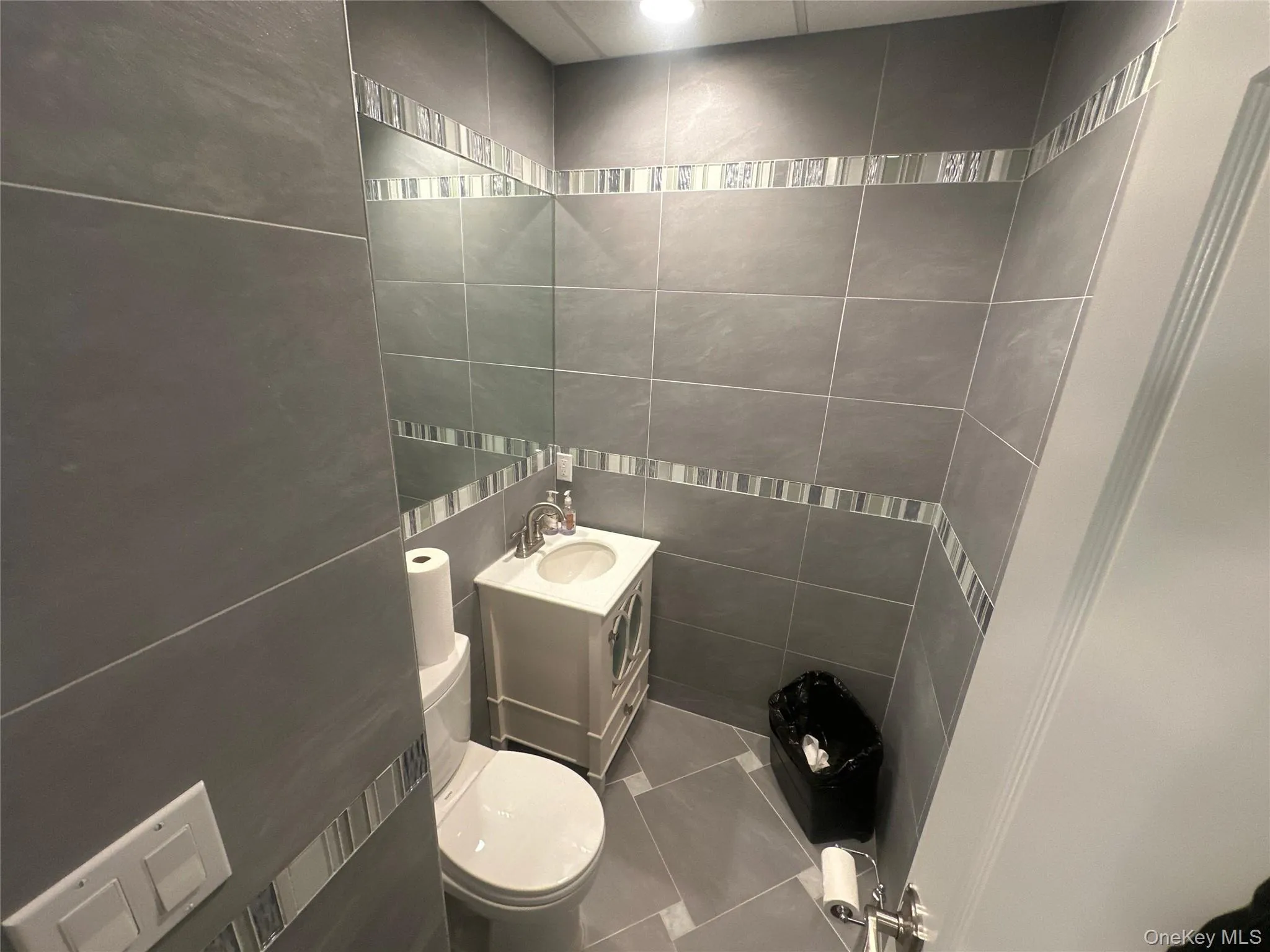 Bathroom with vanity, tile walls, and tile patterned flooring Bathroom with vanity, tile walls, and tile patterned flooring