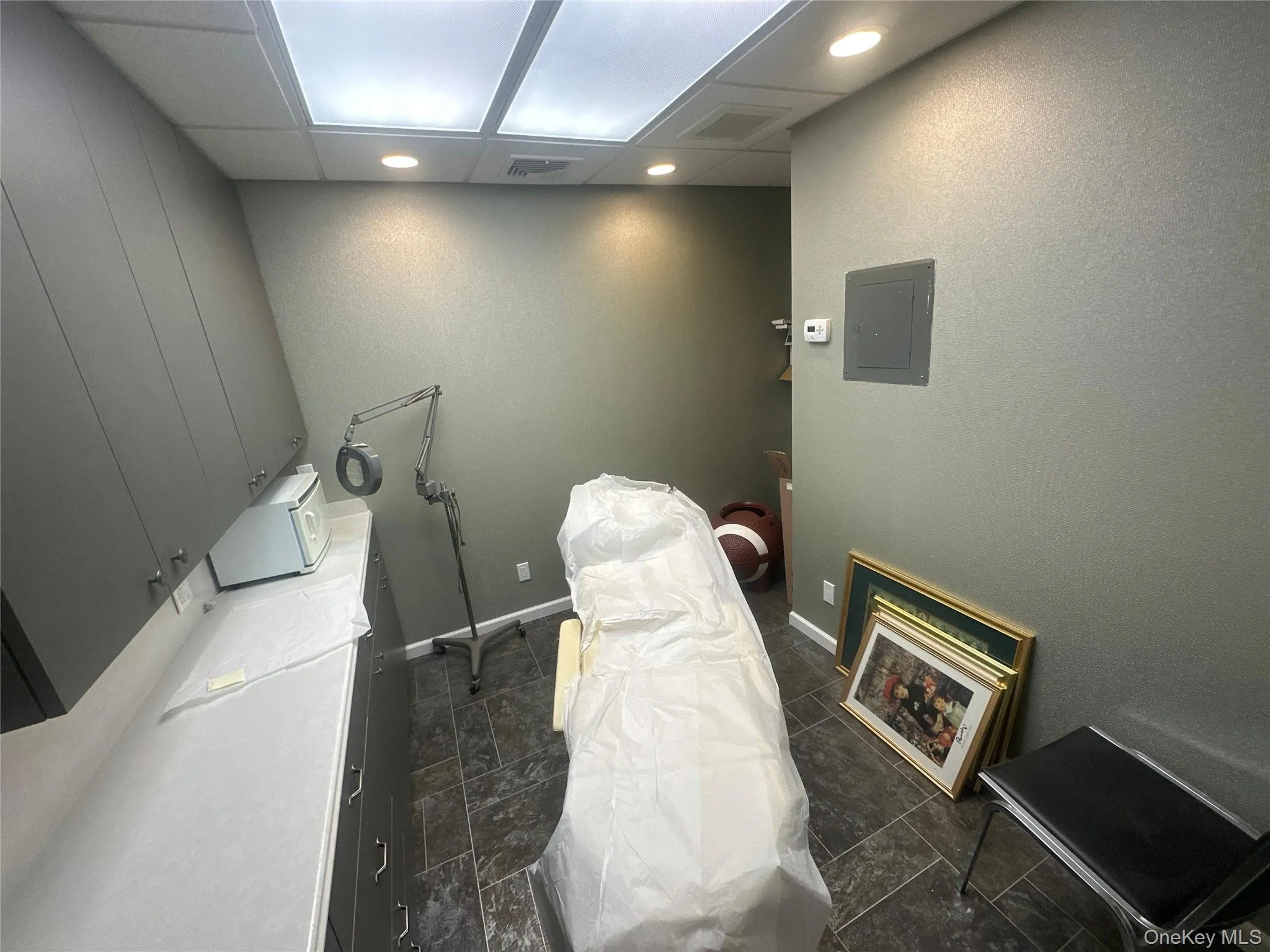 Laundry area featuring electric panel, recessed lighting, and a textured wall Laundry area featuring electric panel, recessed lighting, and a textured wall