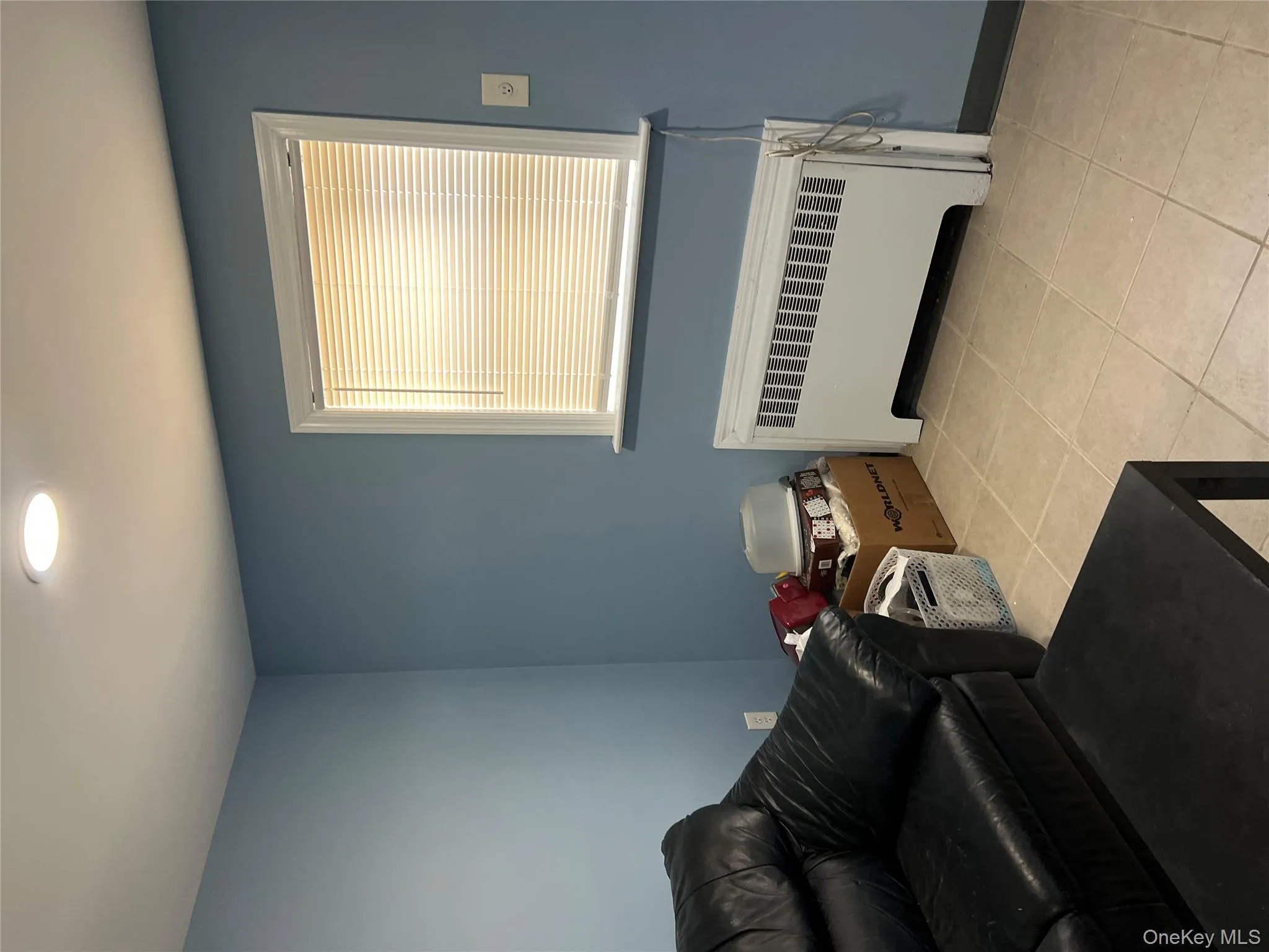 Living area featuring radiator, light tile patterned floors, and recessed lighting Living area featuring radiator, light tile patterned floors, and recessed lighting