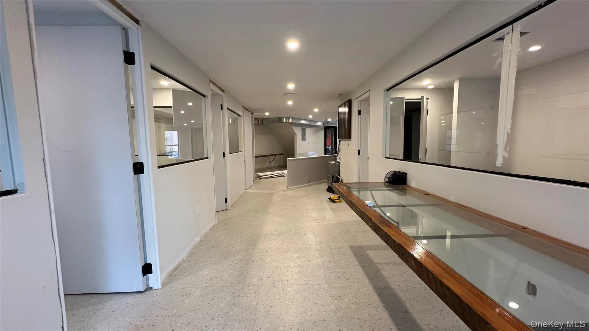 Hallway featuring recessed lighting and dark speckled floor Hallway featuring recessed lighting and dark speckled floor
