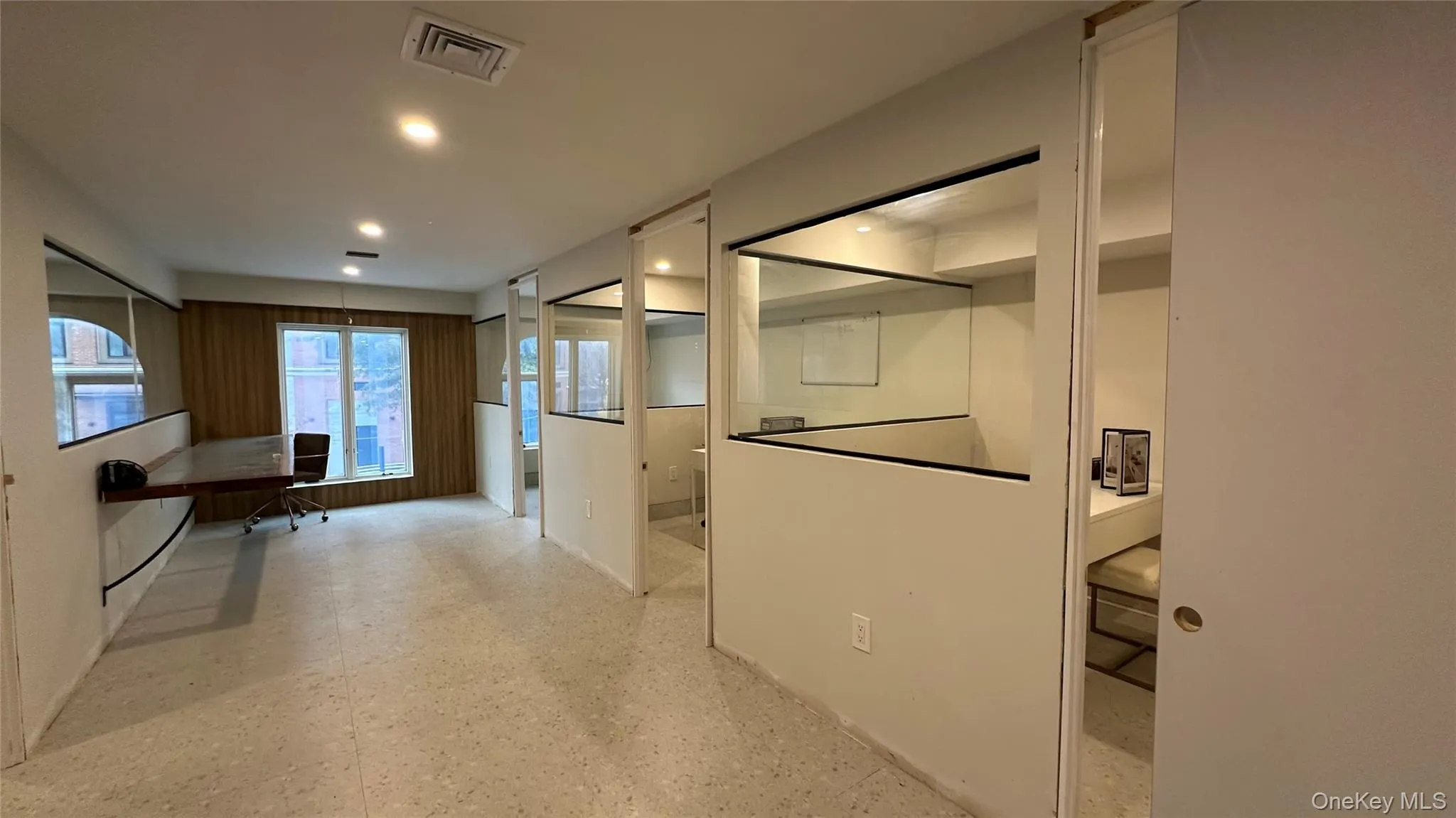 Hallway featuring light flooring, a desk, and recessed lighting Hallway featuring light flooring, a desk, and recessed lighting