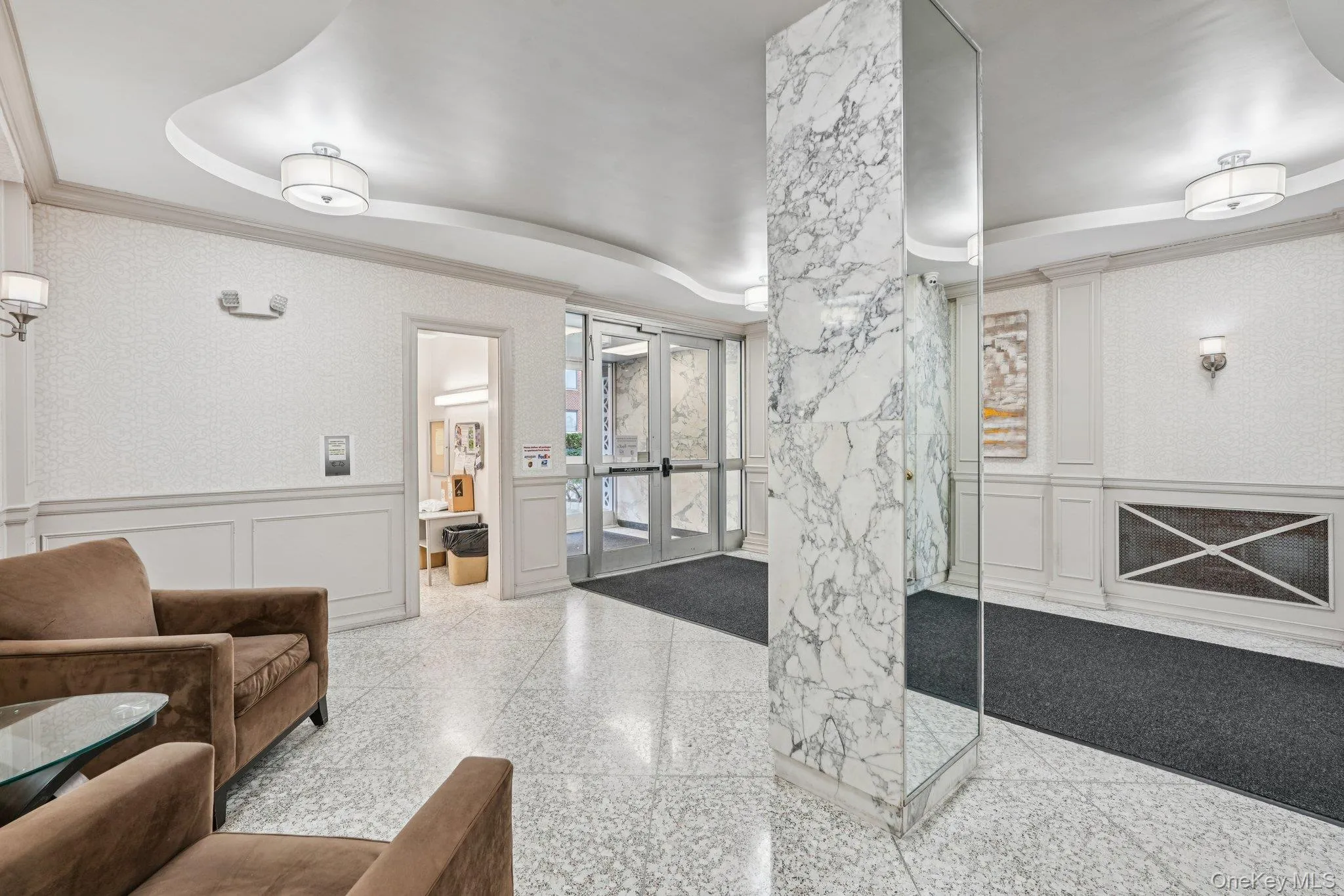 Community lobby featuring a decorative wall, a wainscoted wall, and ornamental molding Community lobby featuring a decorative wall, a wainscoted wall, and ornamental molding