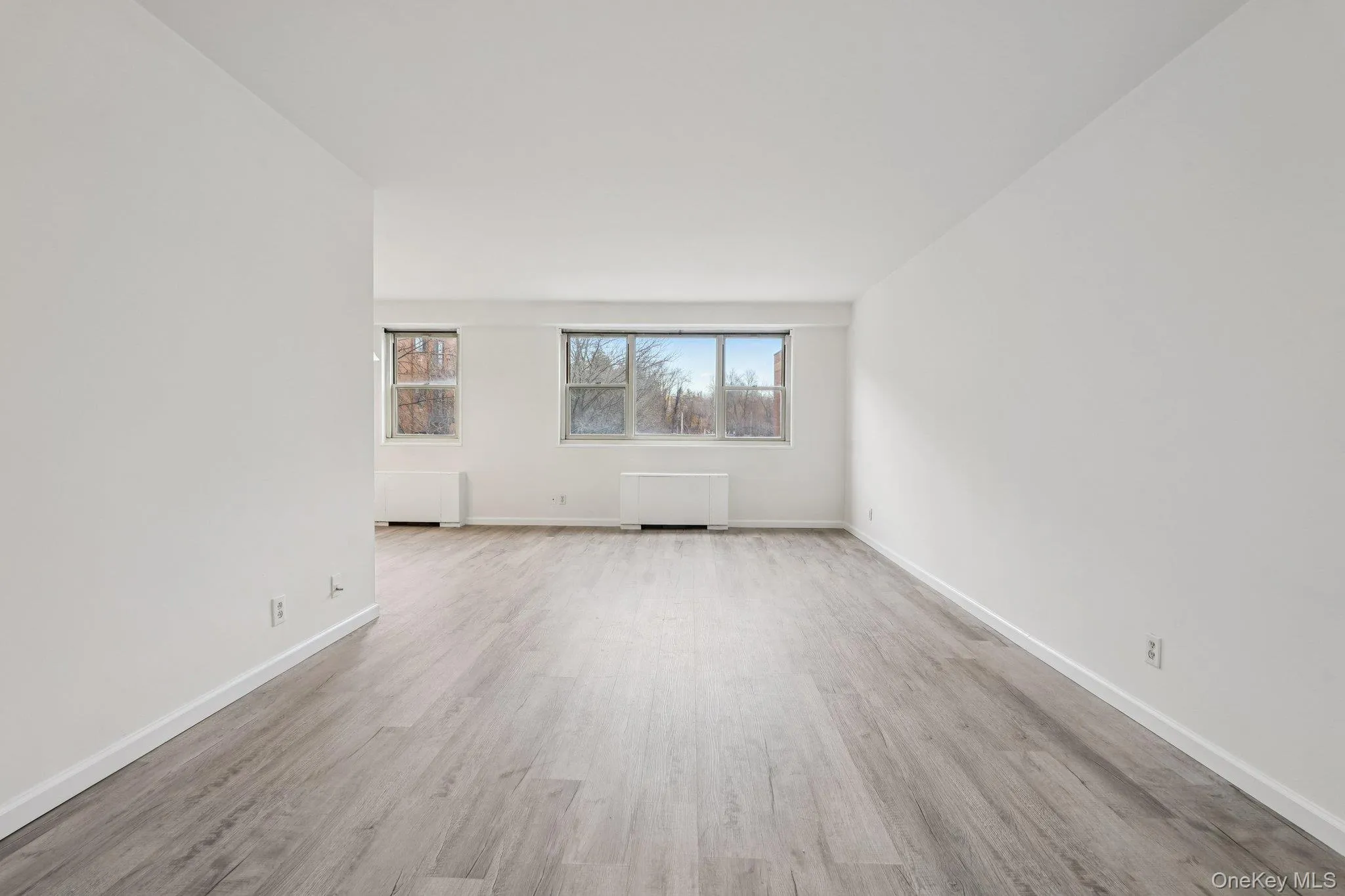 Empty room featuring light wood-type flooring and radiator Empty room featuring light wood-type flooring and radiator