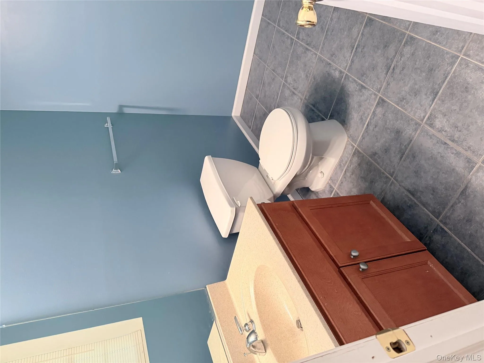 Bathroom with vanity and dark tile patterned floors Bathroom with vanity and dark tile patterned floors