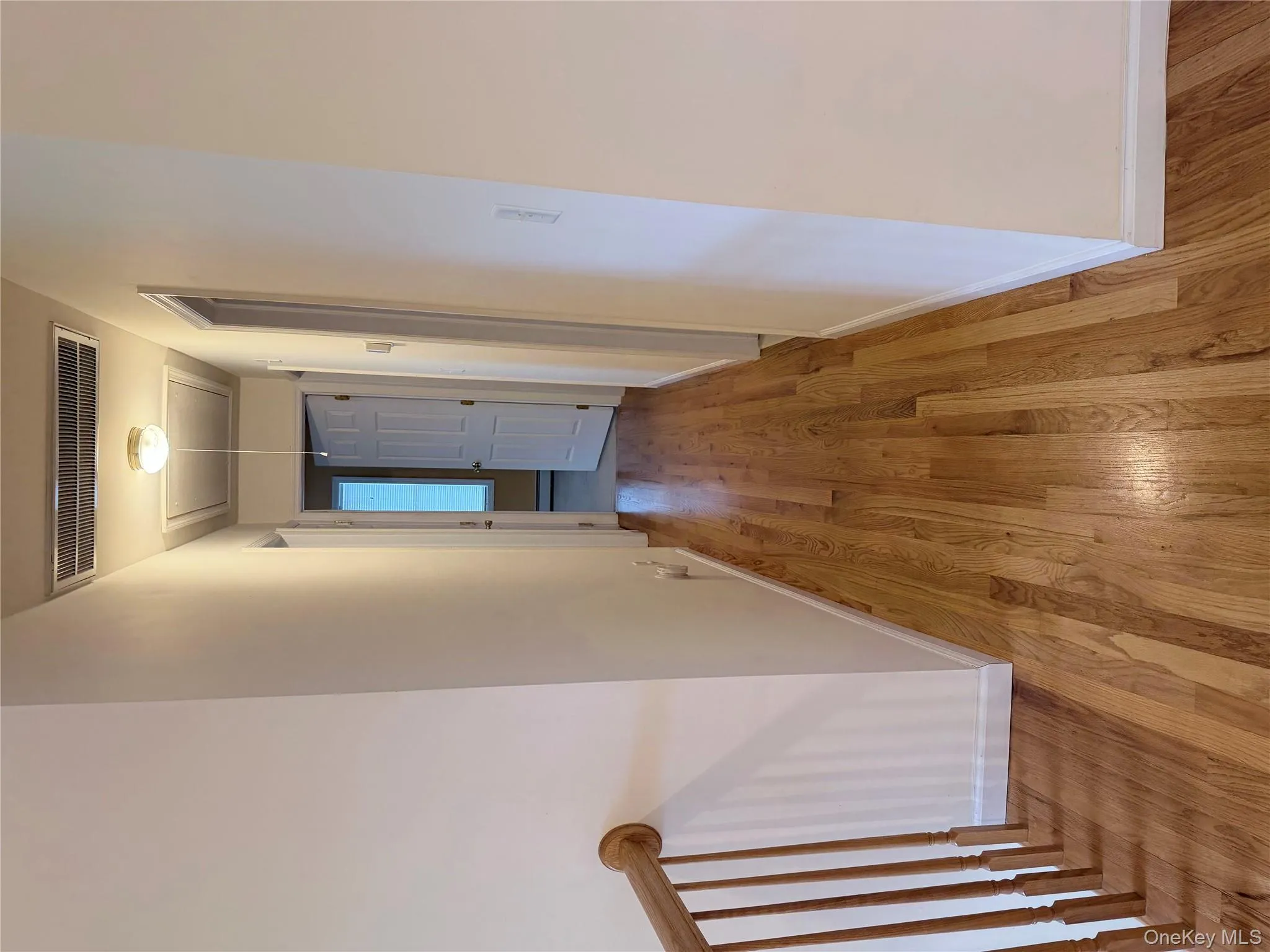 Hallway featuring attic access and light wood finished floors Hallway featuring attic access and light wood finished floors