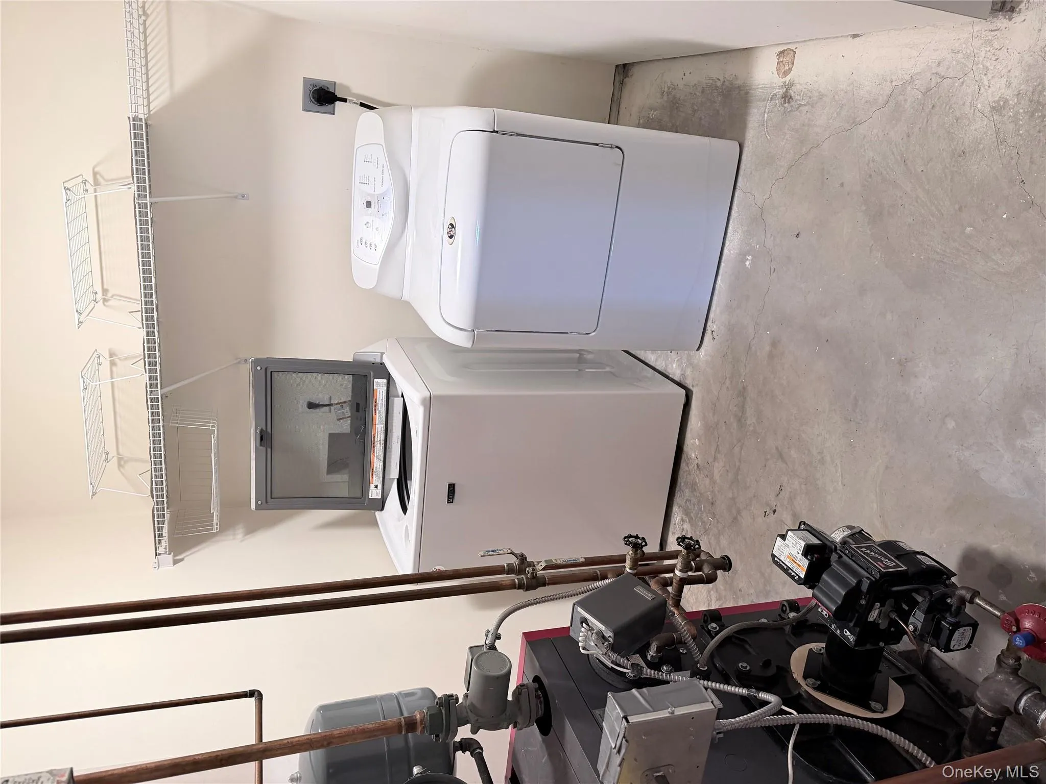 Laundry room featuring unfinished concrete floors, a heating unit, and independent washer and dryer Laundry room featuring unfinished concrete floors, a heating unit, and independent washer and dryer