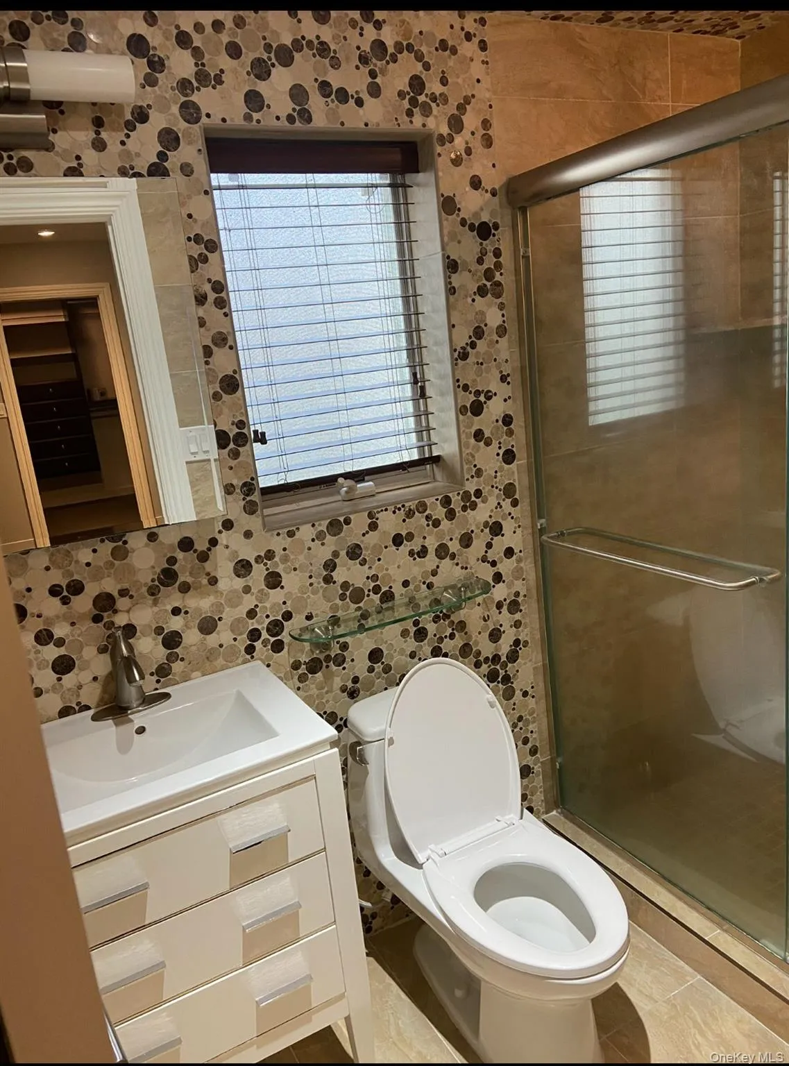 Bathroom featuring vanity, a shower stall, and tile patterned floors Bathroom featuring vanity, a shower stall, and tile patterned floors