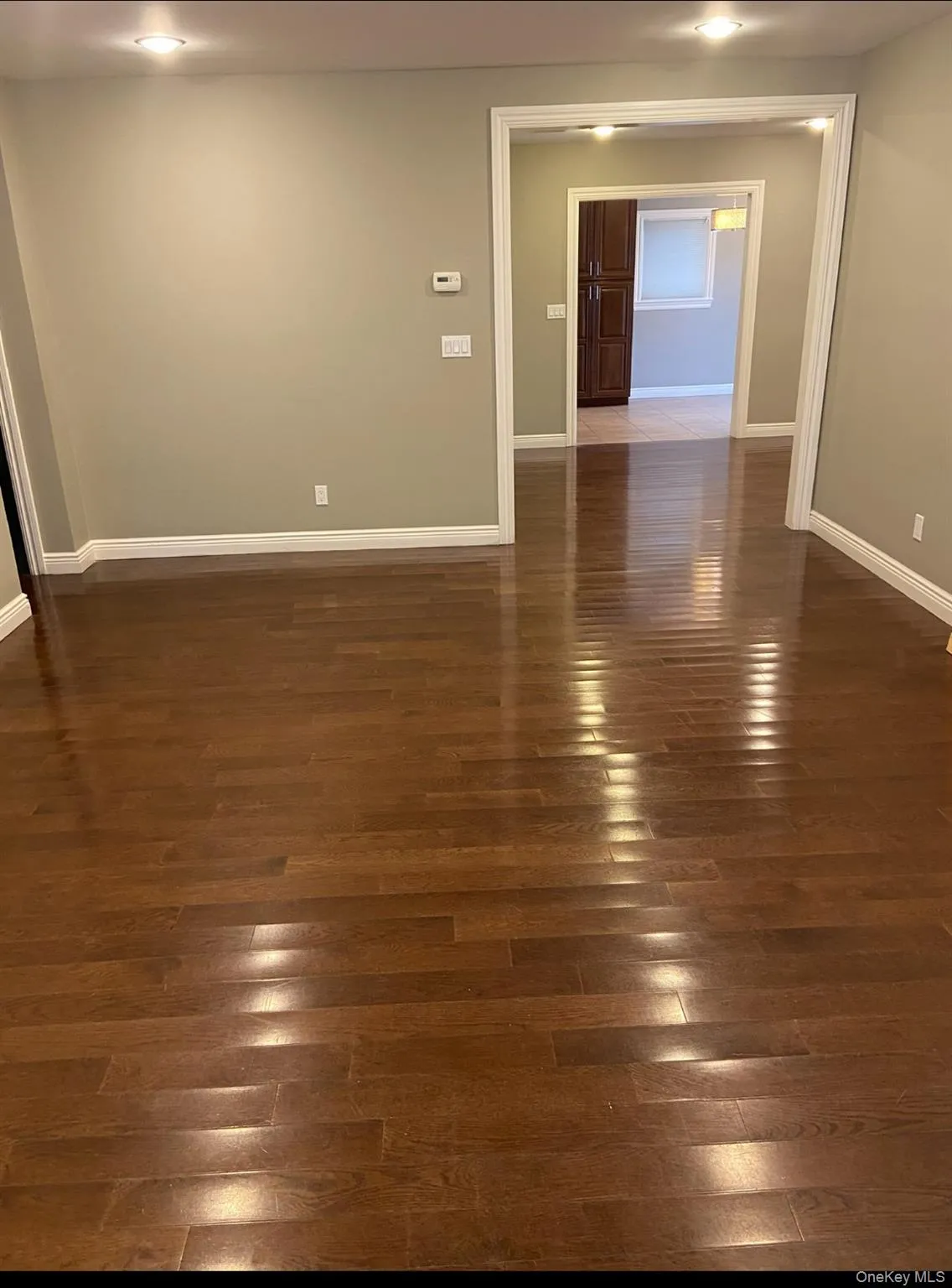 Spare room featuring dark wood-style floors and baseboards Spare room featuring dark wood-style floors and baseboards