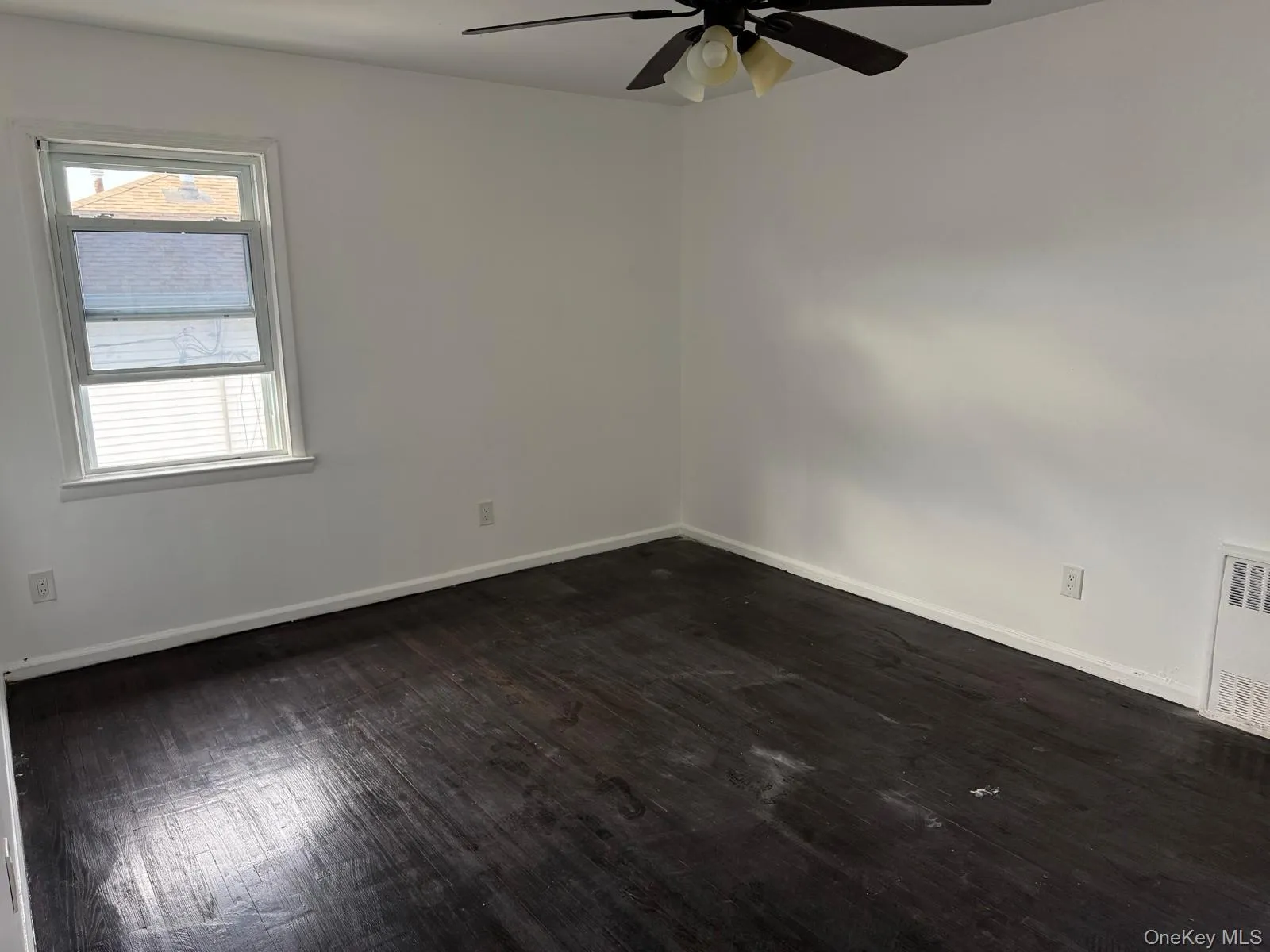 Empty room featuring dark wood-style floors and ceiling fan Empty room featuring dark wood-style floors and ceiling fan