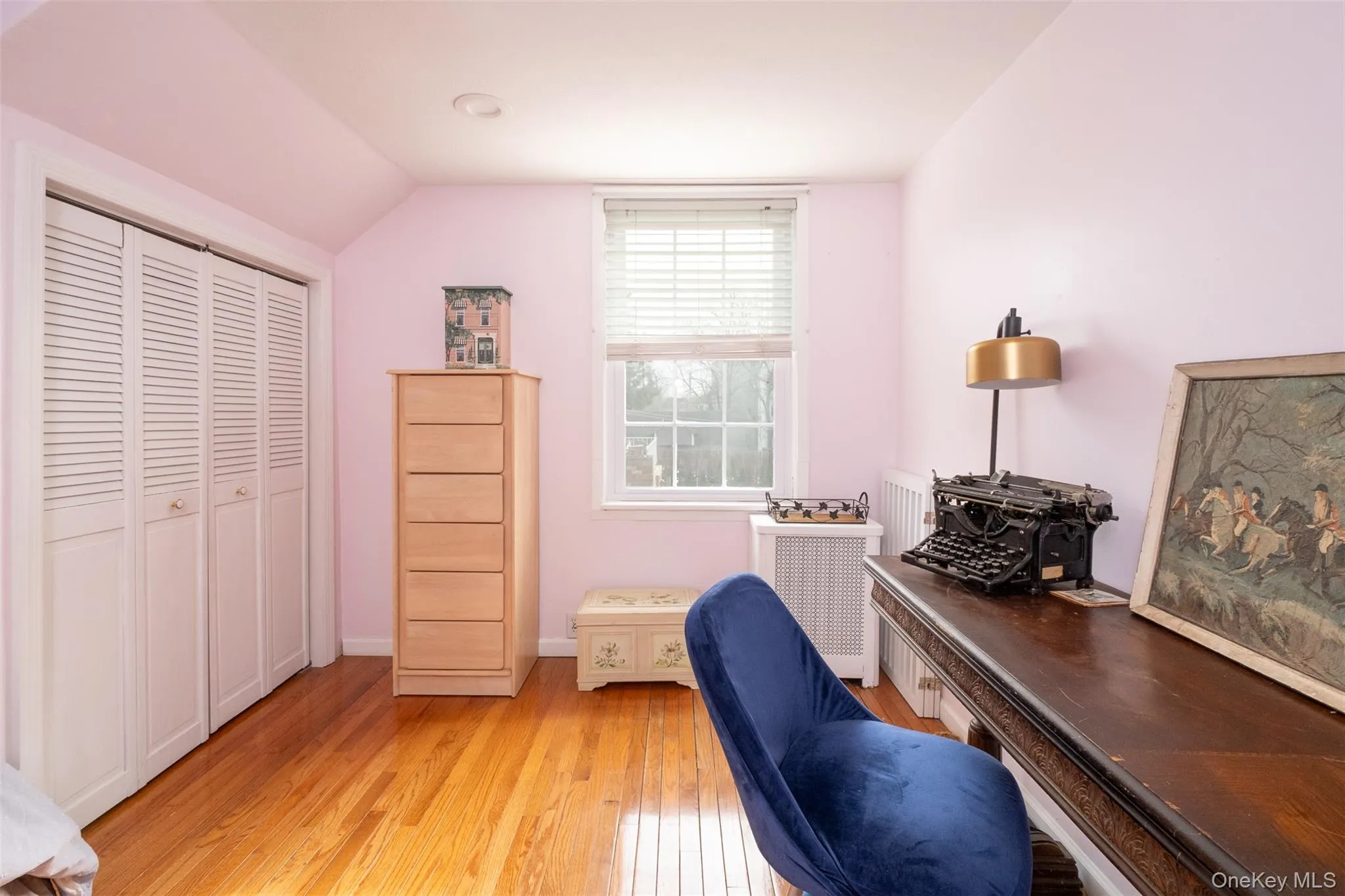 Office area featuring radiator heating unit, light wood-style flooring, and vaulted ceiling Office area featuring radiator heating unit, light wood-style flooring, and vaulted ceiling